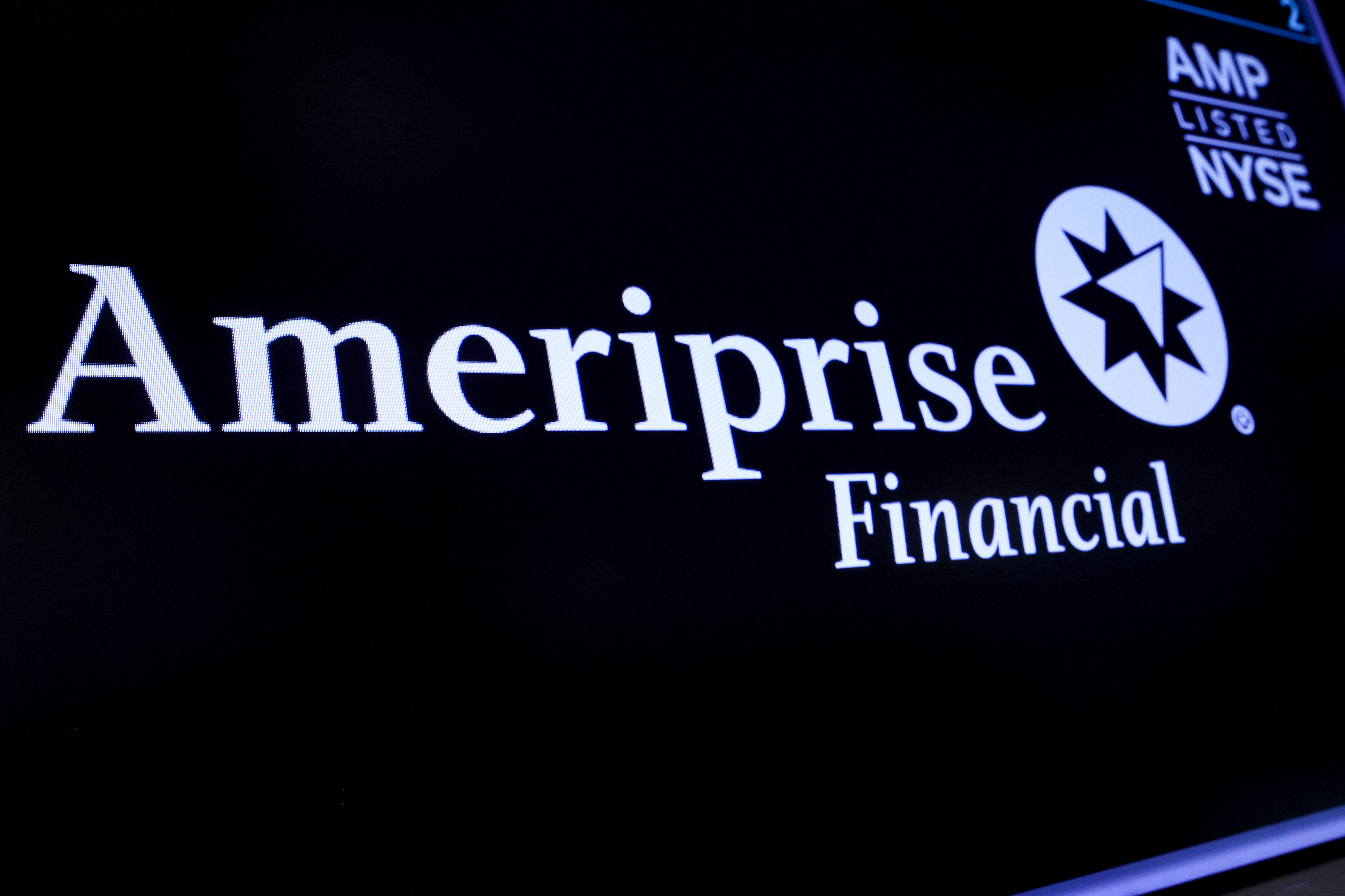 A screen displays the logo and trading information for Ameriprise Financial, Inc. on the floor of the NYSE in New York