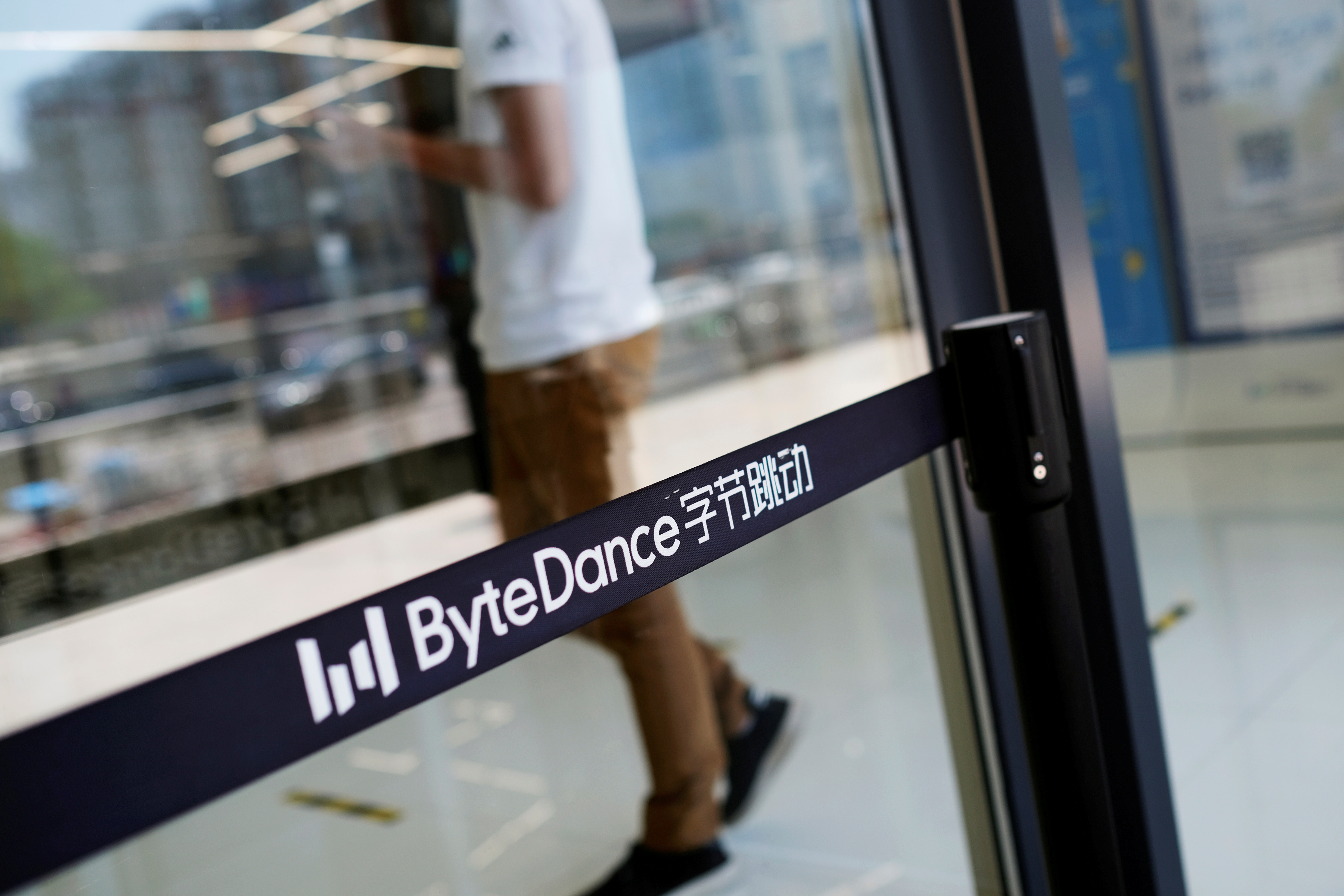 A man walks by a logo of Bytedance, the China-based company which owns the short video app TikTok, or Douyin, at its office in Beijing, China July 7, 2020.  REUTERS/Thomas Suen