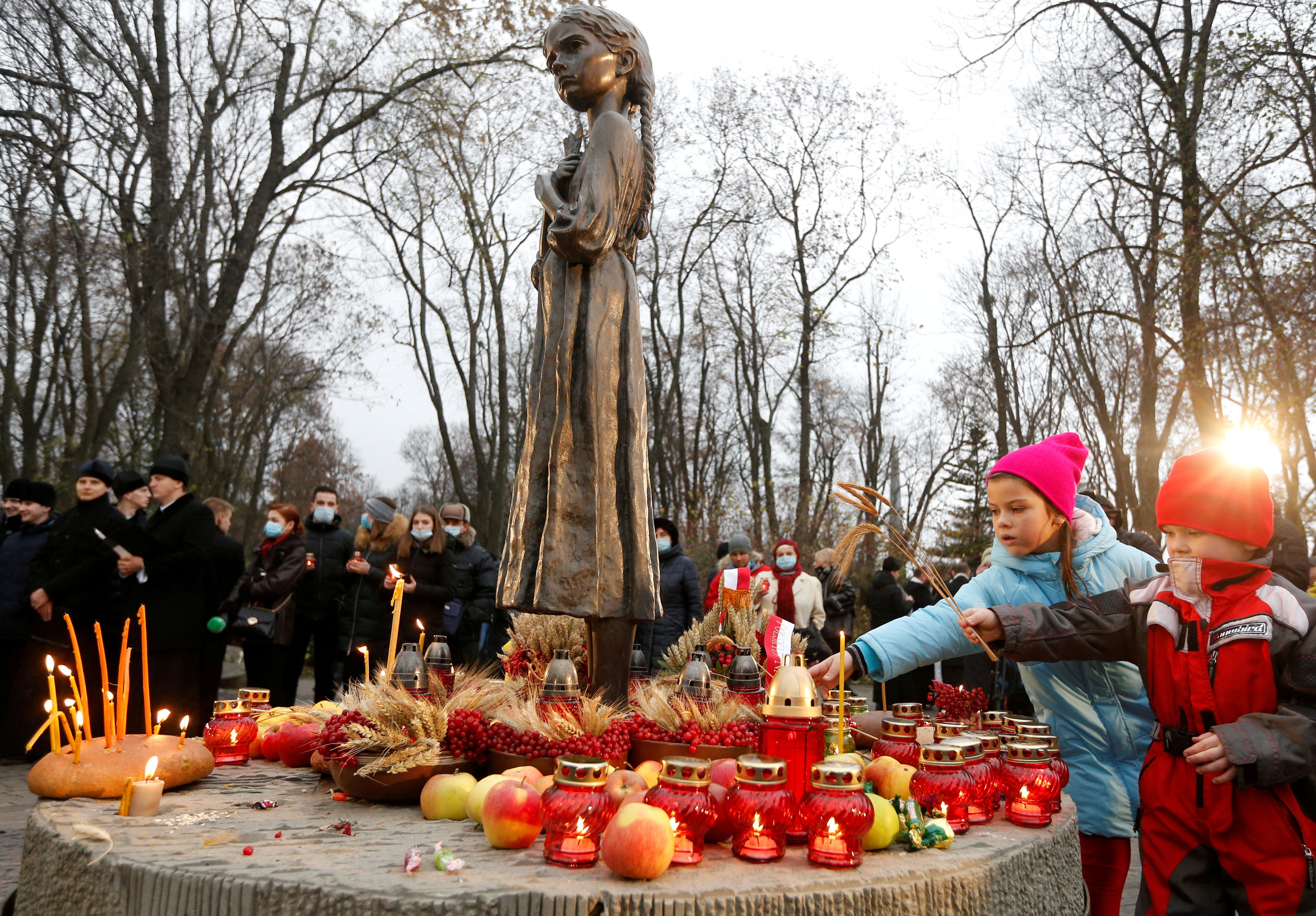 People visit a monument to Holodomor victims in Kyiv