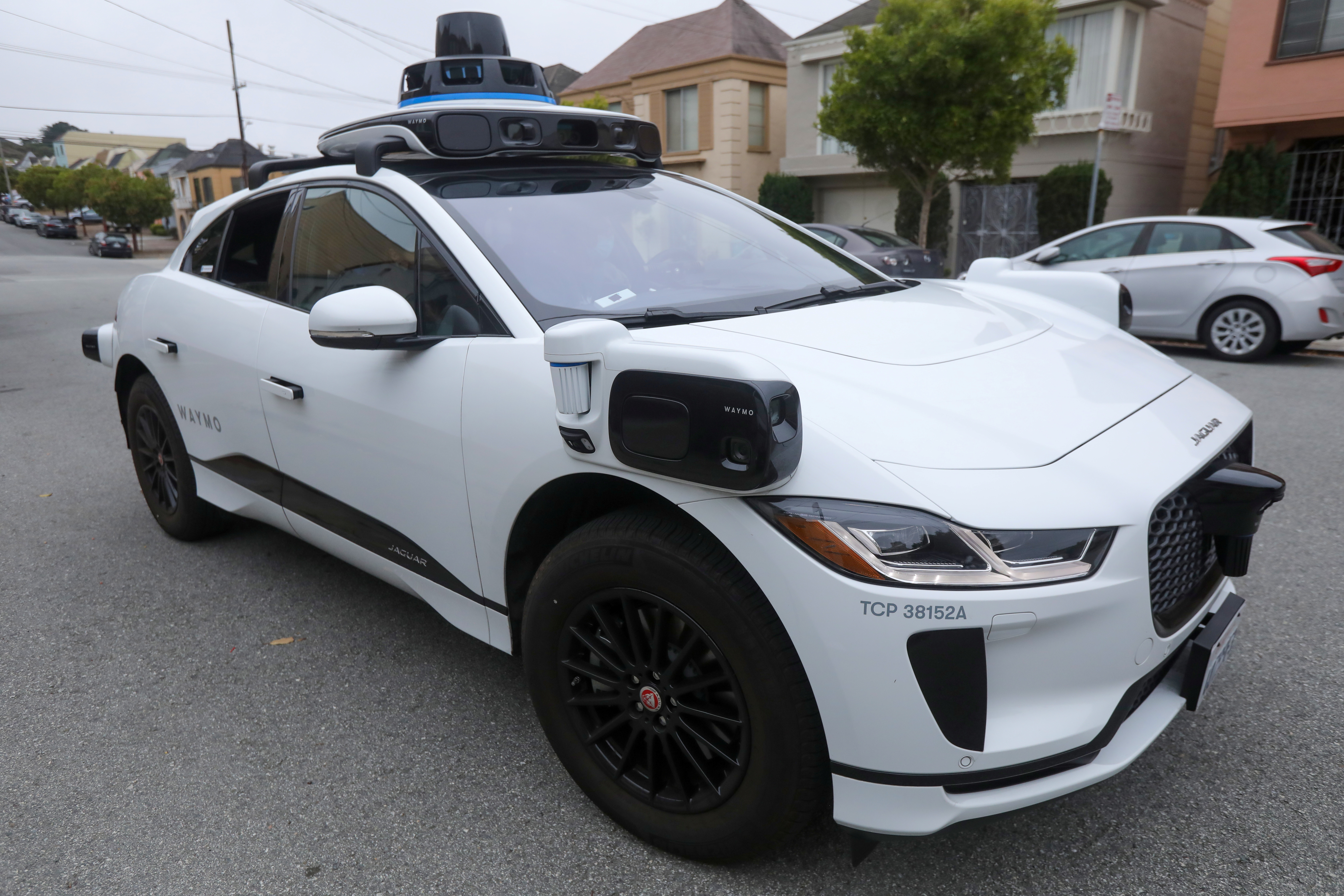 A Waymo Jaguar I-Pace SUV is seen driving on a road in San Francisco