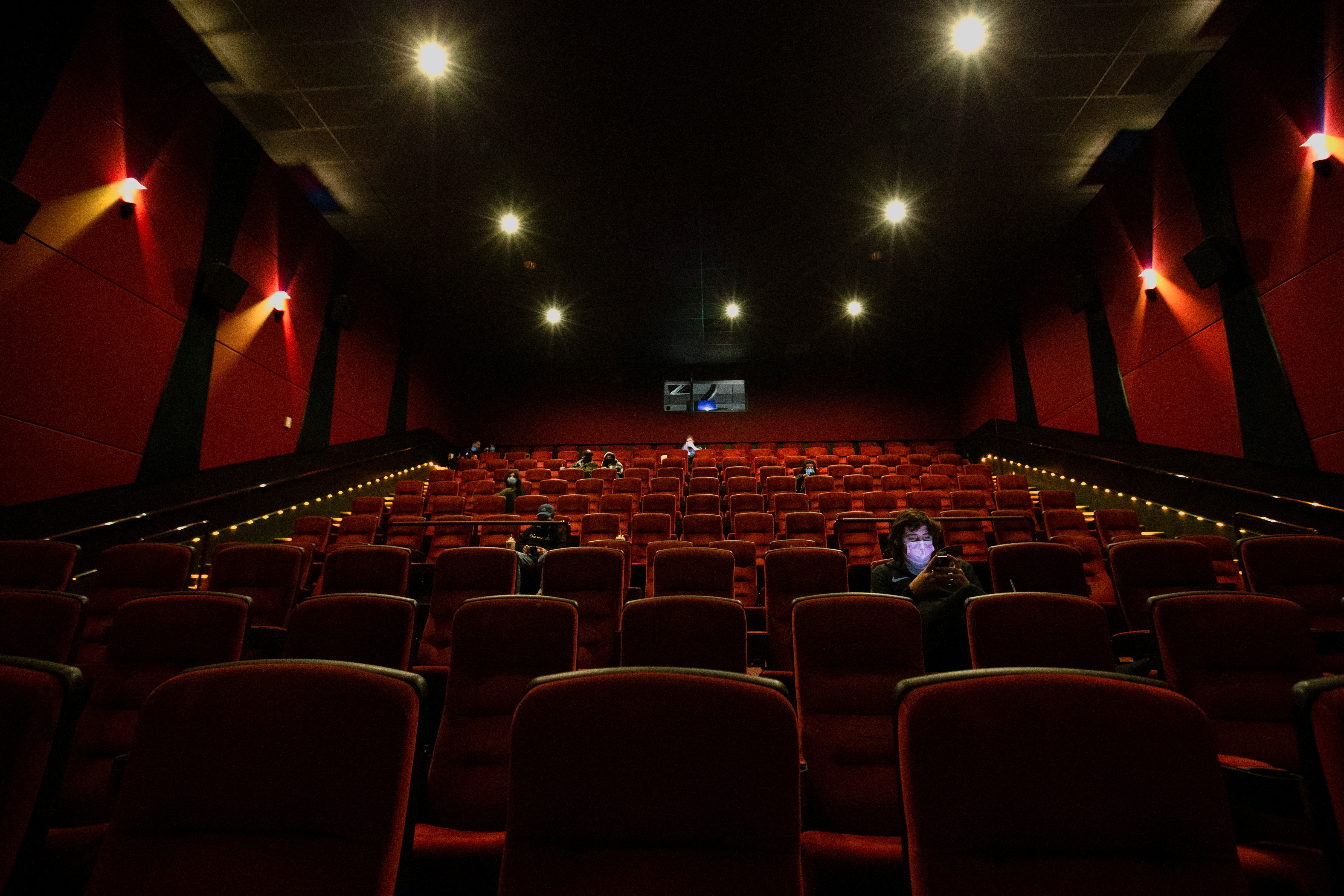 Patrons sit in a nearly empty AMC theatre while they wait for the first screening on reopening day during the outbreak of the coronavirus disease (COVID-19), in Burbank