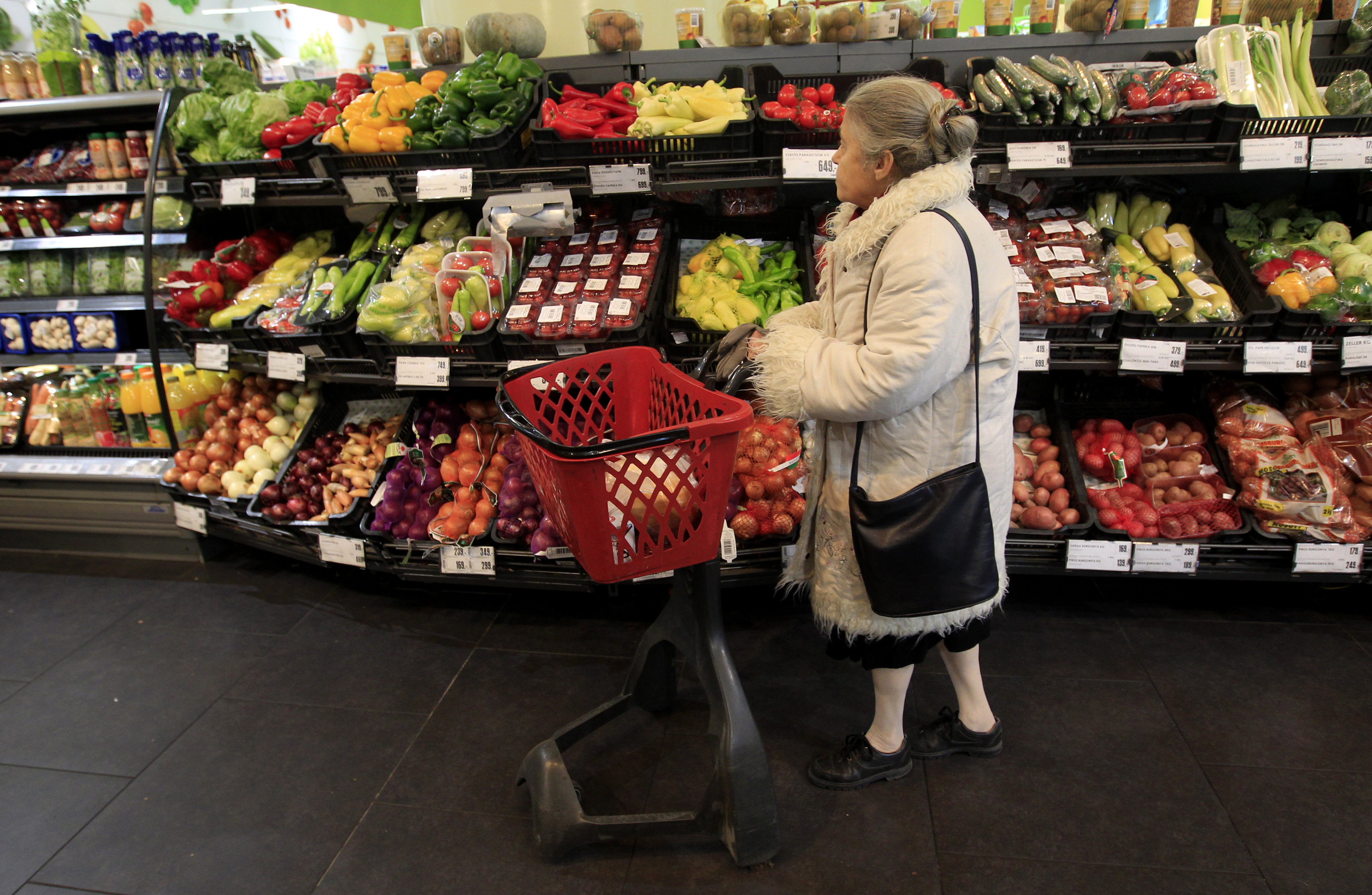 A woman looks at vegetables in a Spar store in Budapest