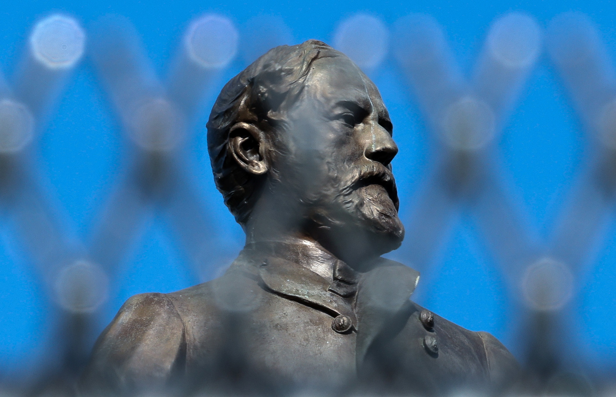 The statue of Confederate General Robert E. Lee stands behind protective fencing the day before the monument will be removed in Richmond