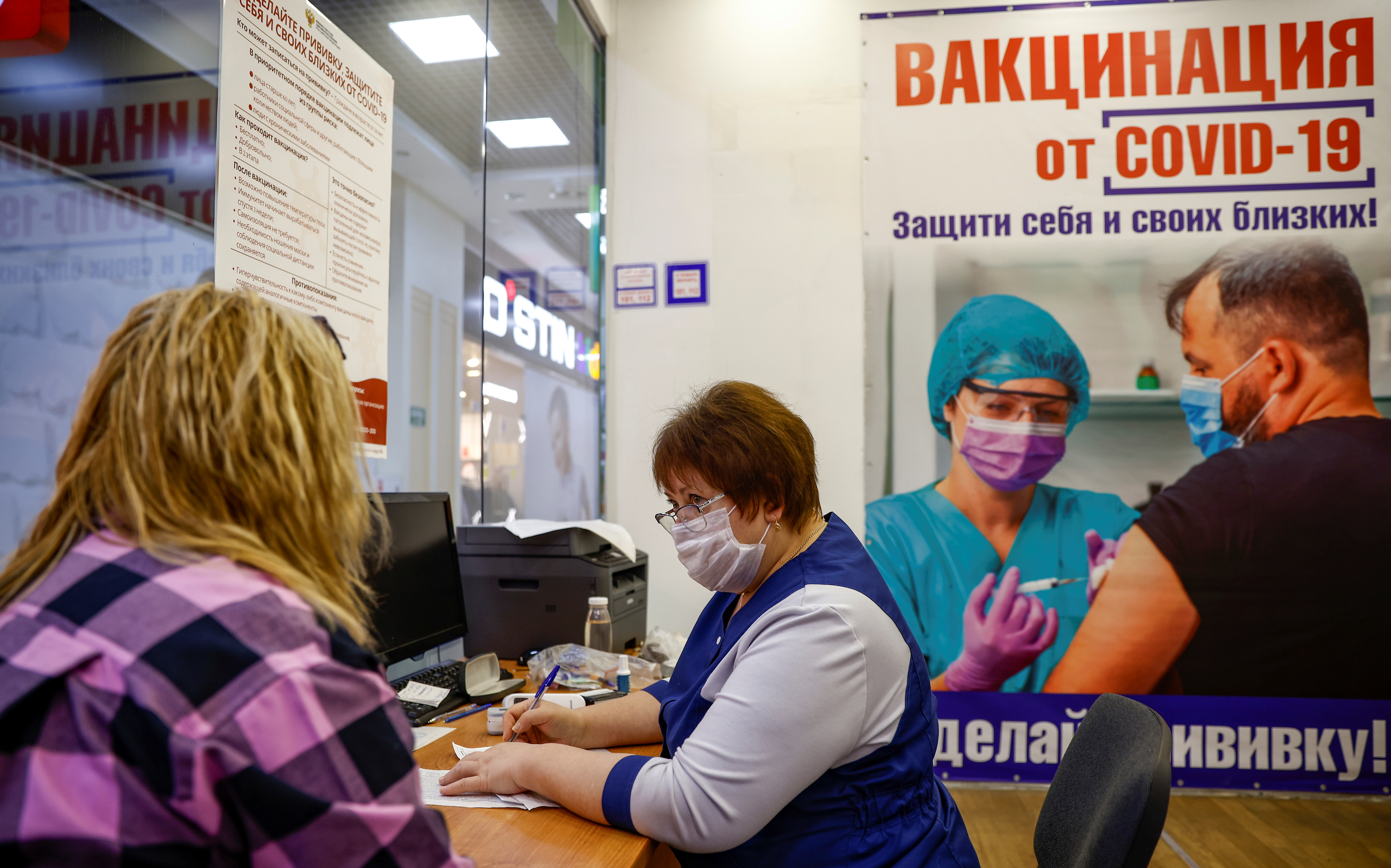 A medical worker registers documents of a patient at a vaccination centre in Oryol
