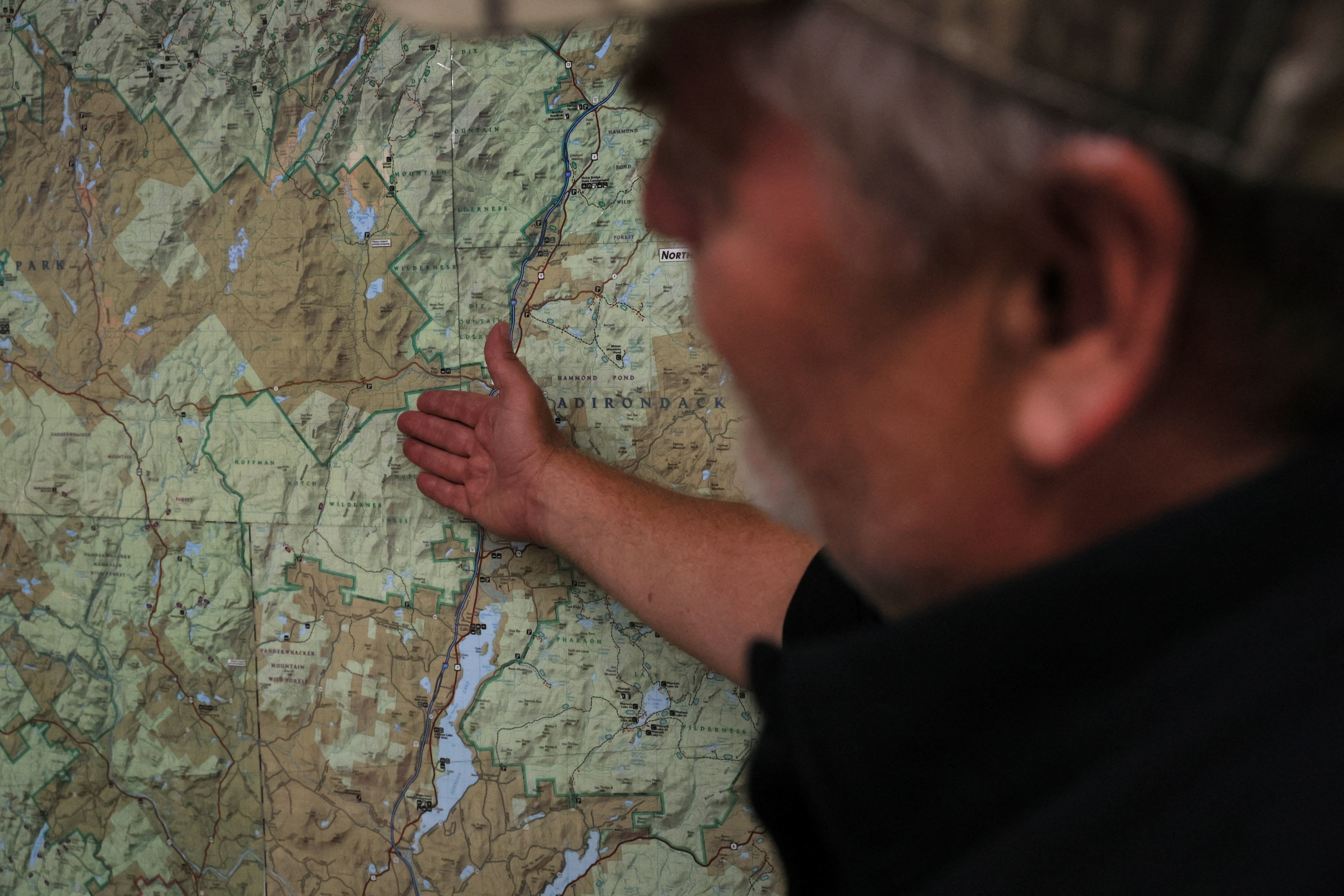 John Bowe, president of Dunhams Bay Fish & Game Club, points to a map at his site in Queensbury