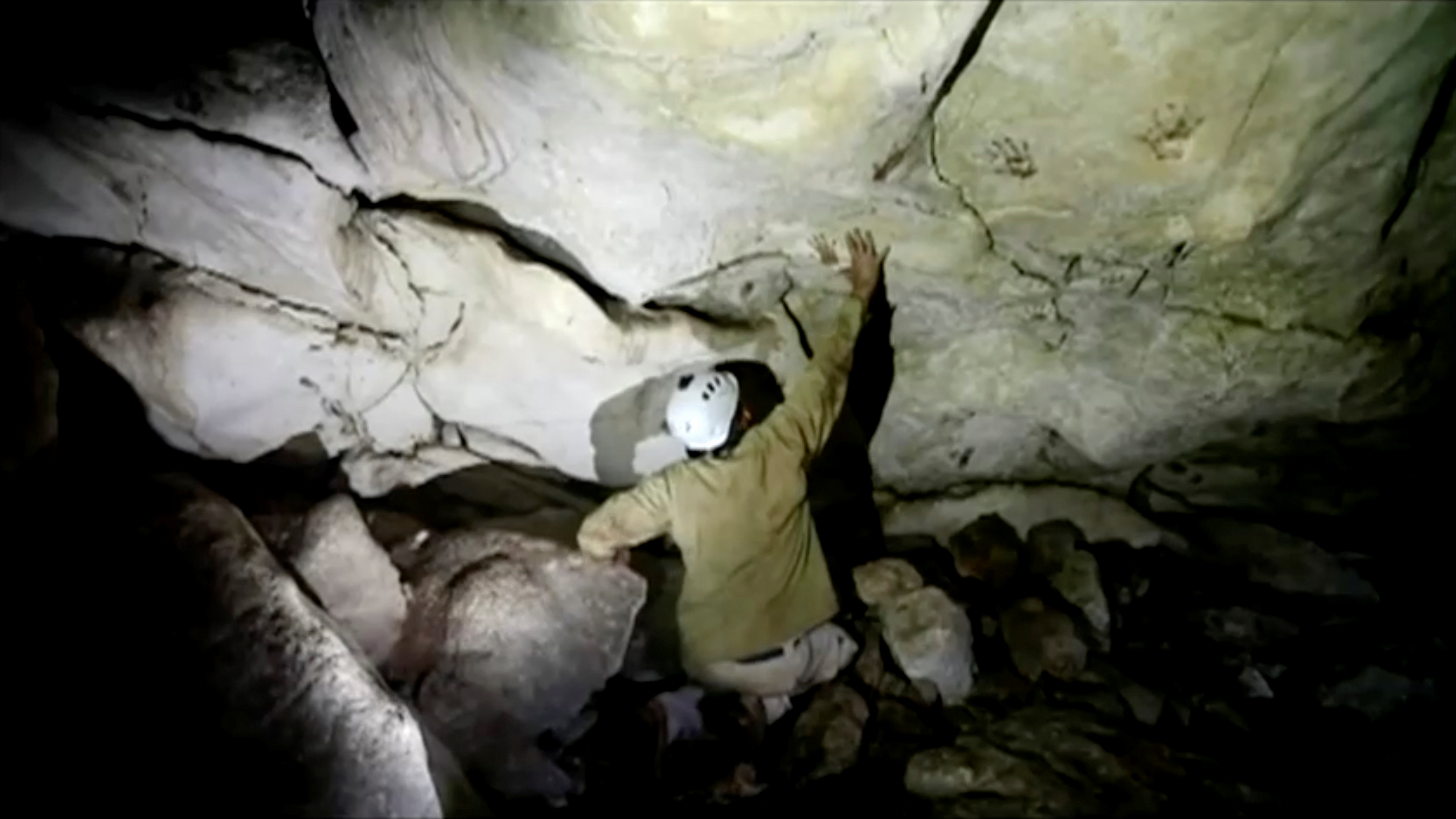 Archeologist Sergio Grosjean explores a cave with hand prints on the walls, in Merida