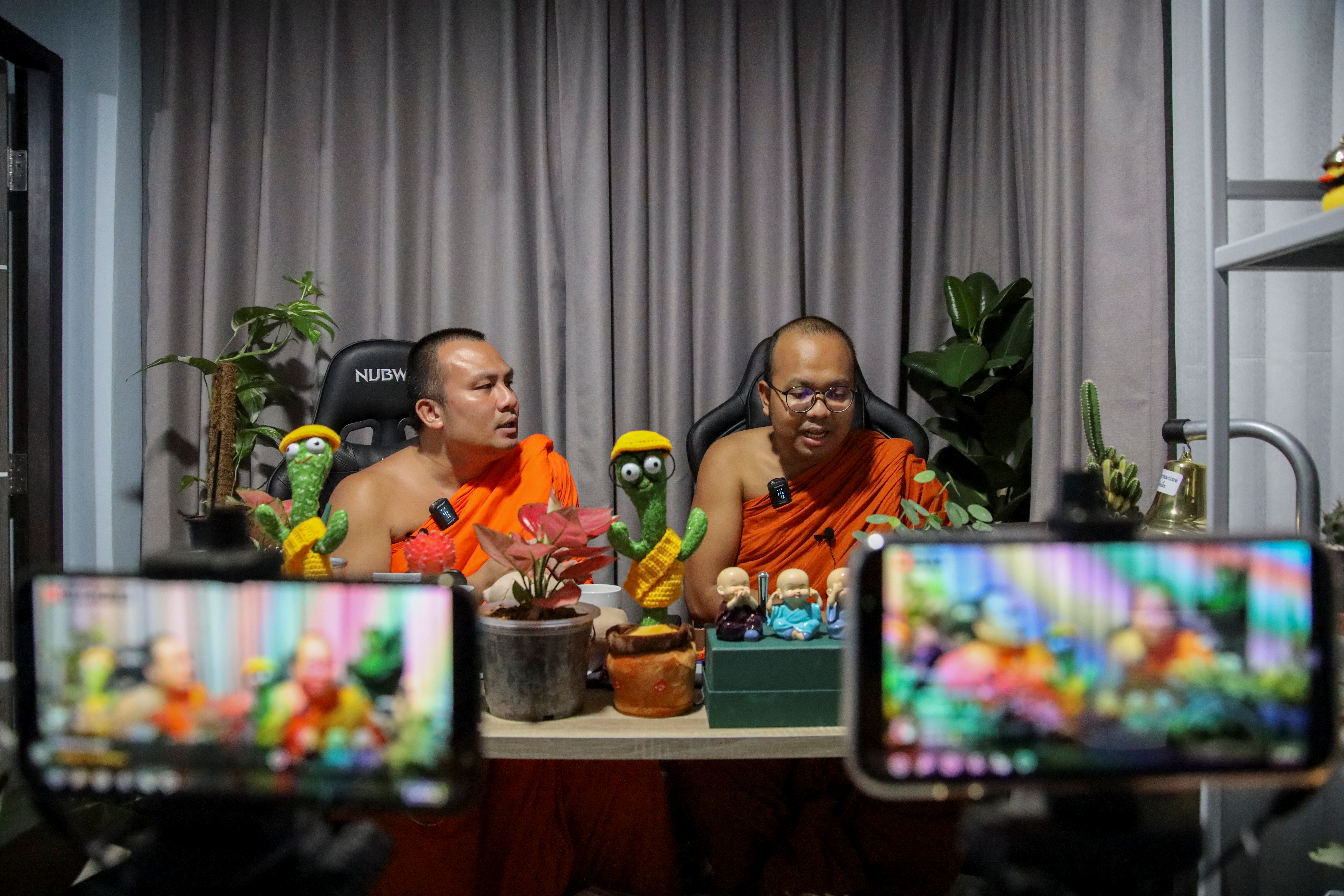 Buddhist monks host a chat show during a Facebook live at a temple in Bangkok