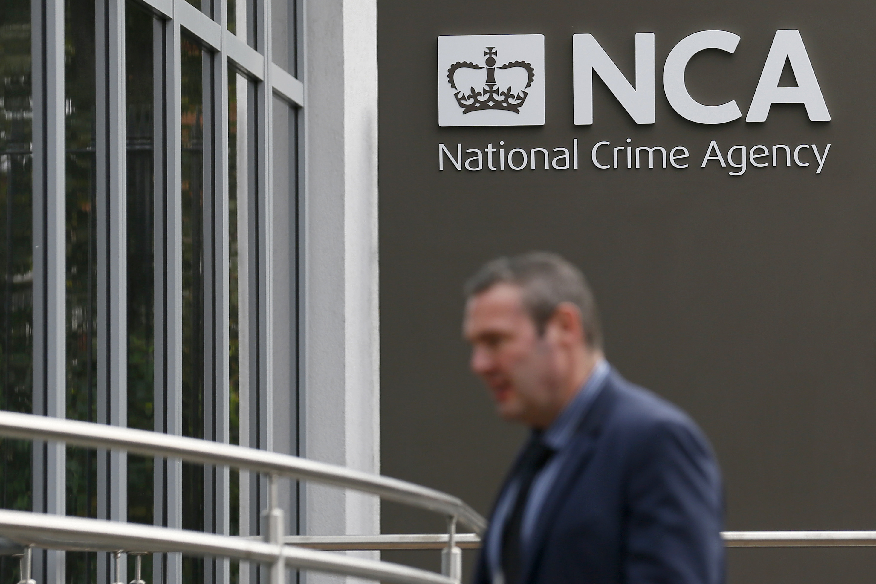 A pedestrian walks past the National Crime Agency headquarters in London