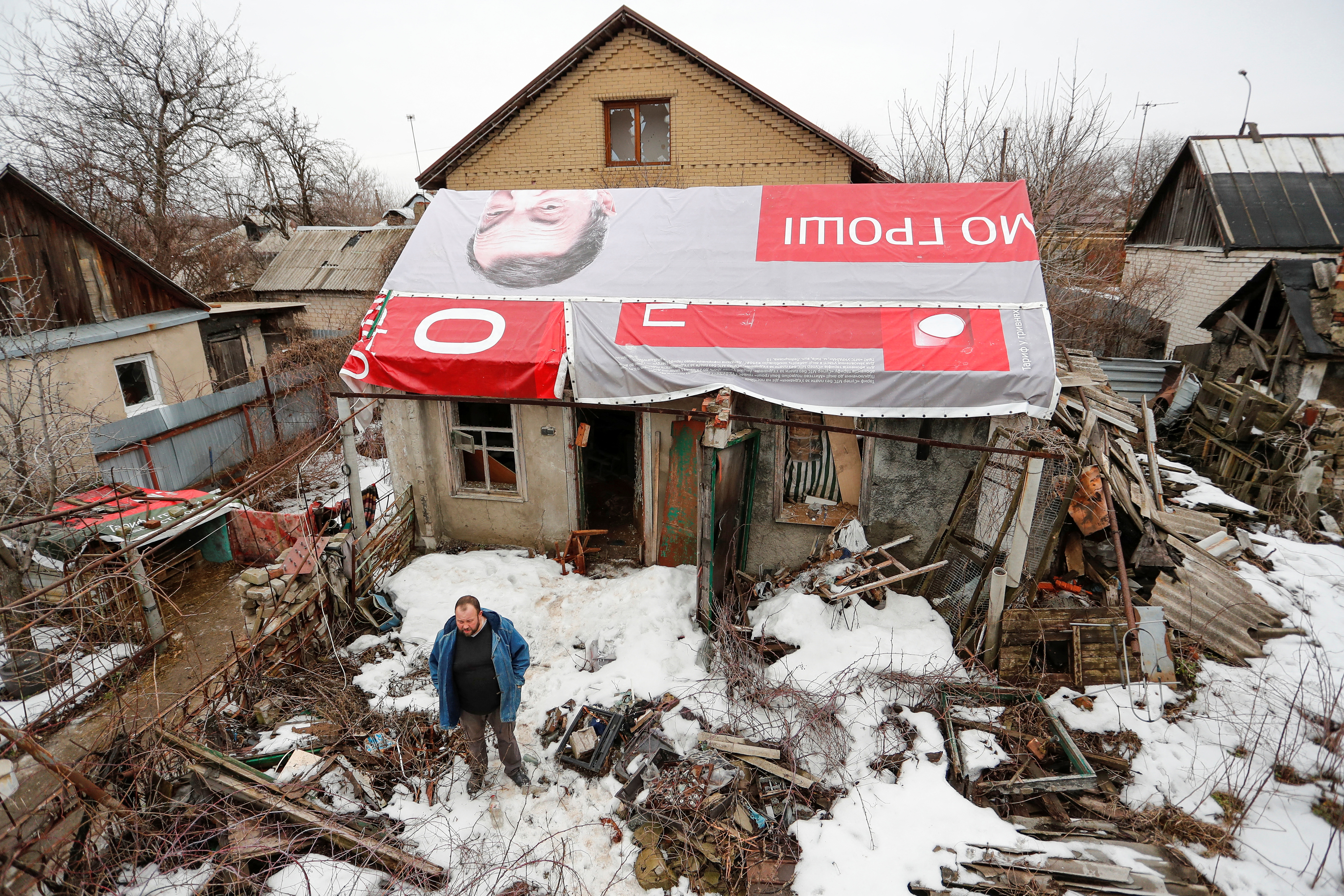 Local resident Boyko stands next to his workshop, damaged by shelling, on the outskirts of rebel-held Donetsk