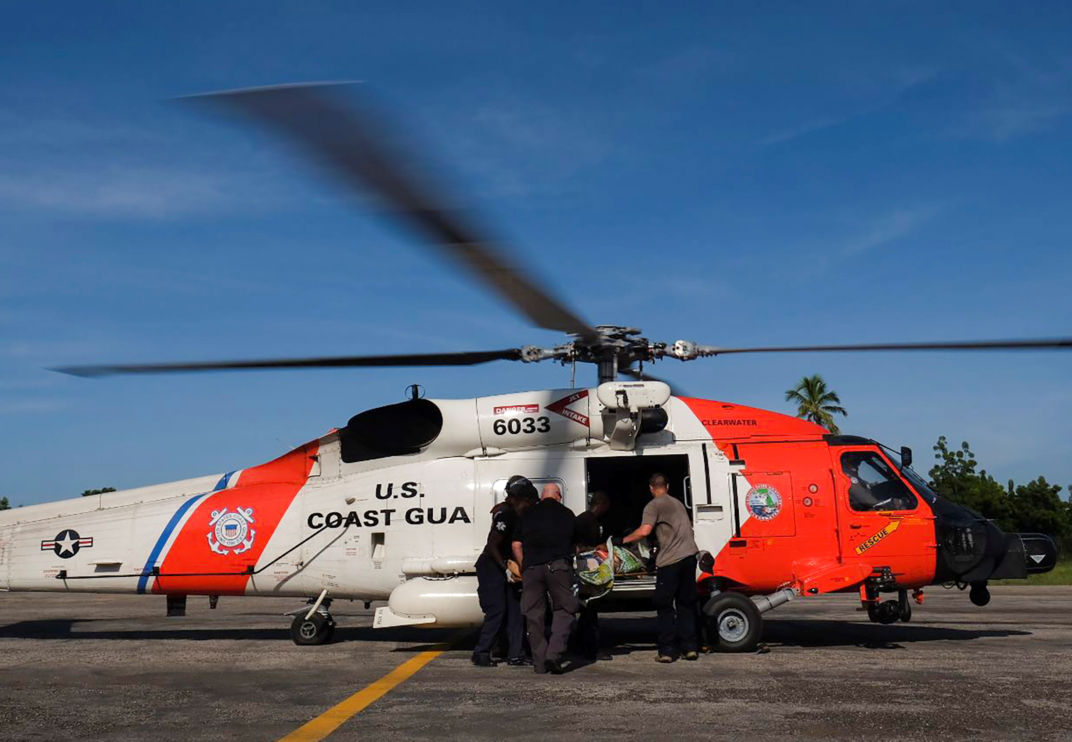 Members of the U.S. Coast Guard board a person who was injured in Saturday's 7.2 magnitude earthquake in a helicopter for evacuation, at the airport, in Les Cayes, Haiti August 16, 2021. REUTERS/Ricardo Arduengo