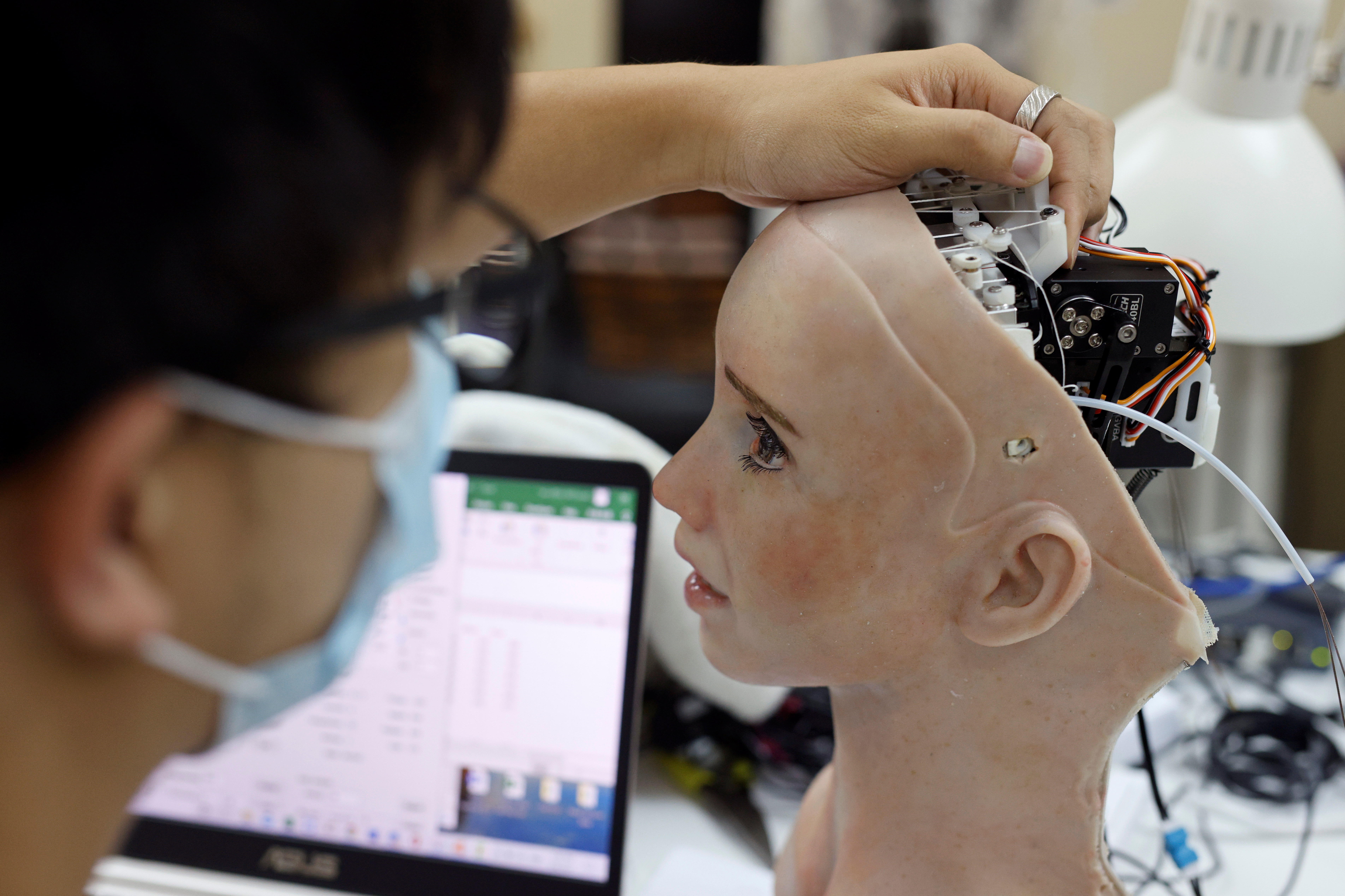 An engineer adjusts the head of humanoid robot Grace, developed by Hanson Robotics and designed for the healthcare market, to interact and comfort the elderly and isolated people, especially those suffering during the coronavirus disease (COVID-19) pandemic, at the company's lab in Hong Kong, China May 4, 2021. Picture taken May 4, 2021. REUTERS/Tyrone Siu