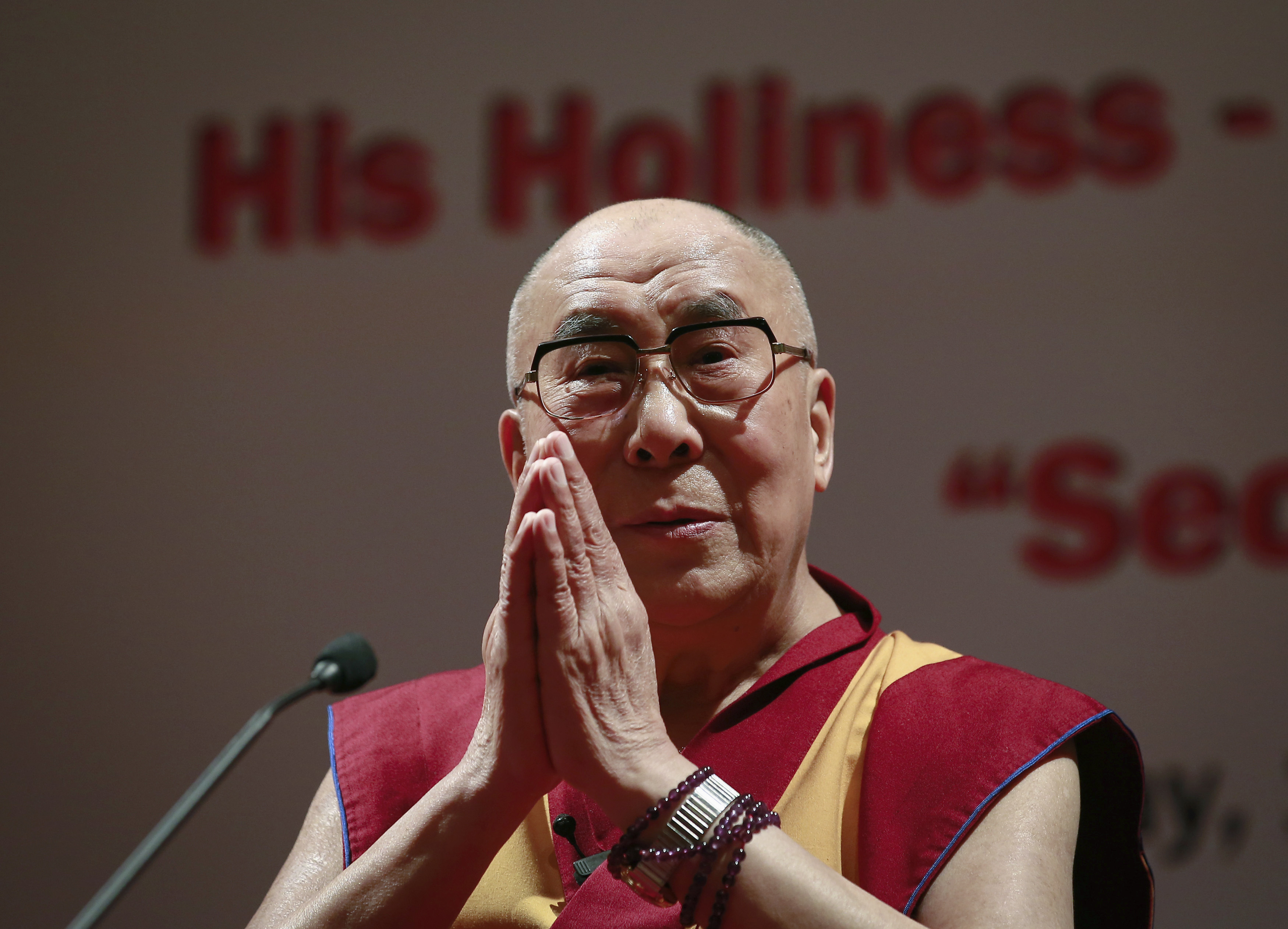 Exiled Tibetan spiritual leader the Dalai Lama gestures during a speech at the 108th anniversary of Indian Merchant Chambers in Mumbai