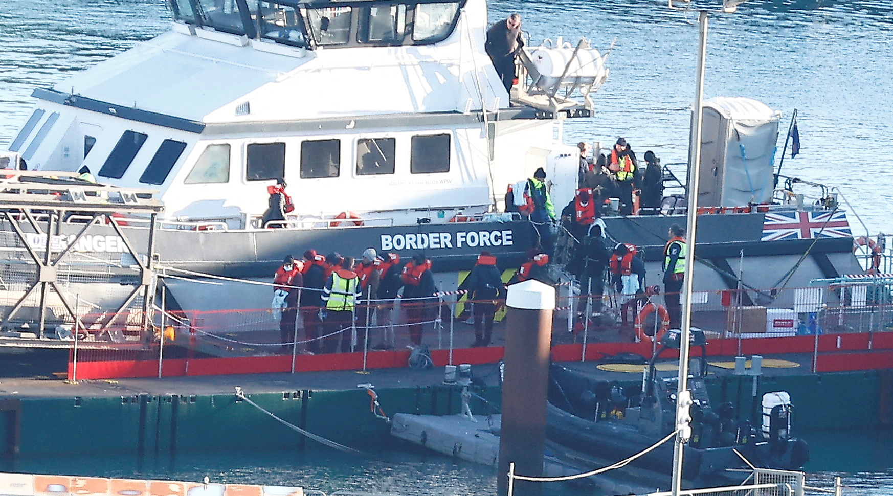 People, believed to be migrants, disembark a Border Force boat at the Border Force processing centre, in Dover