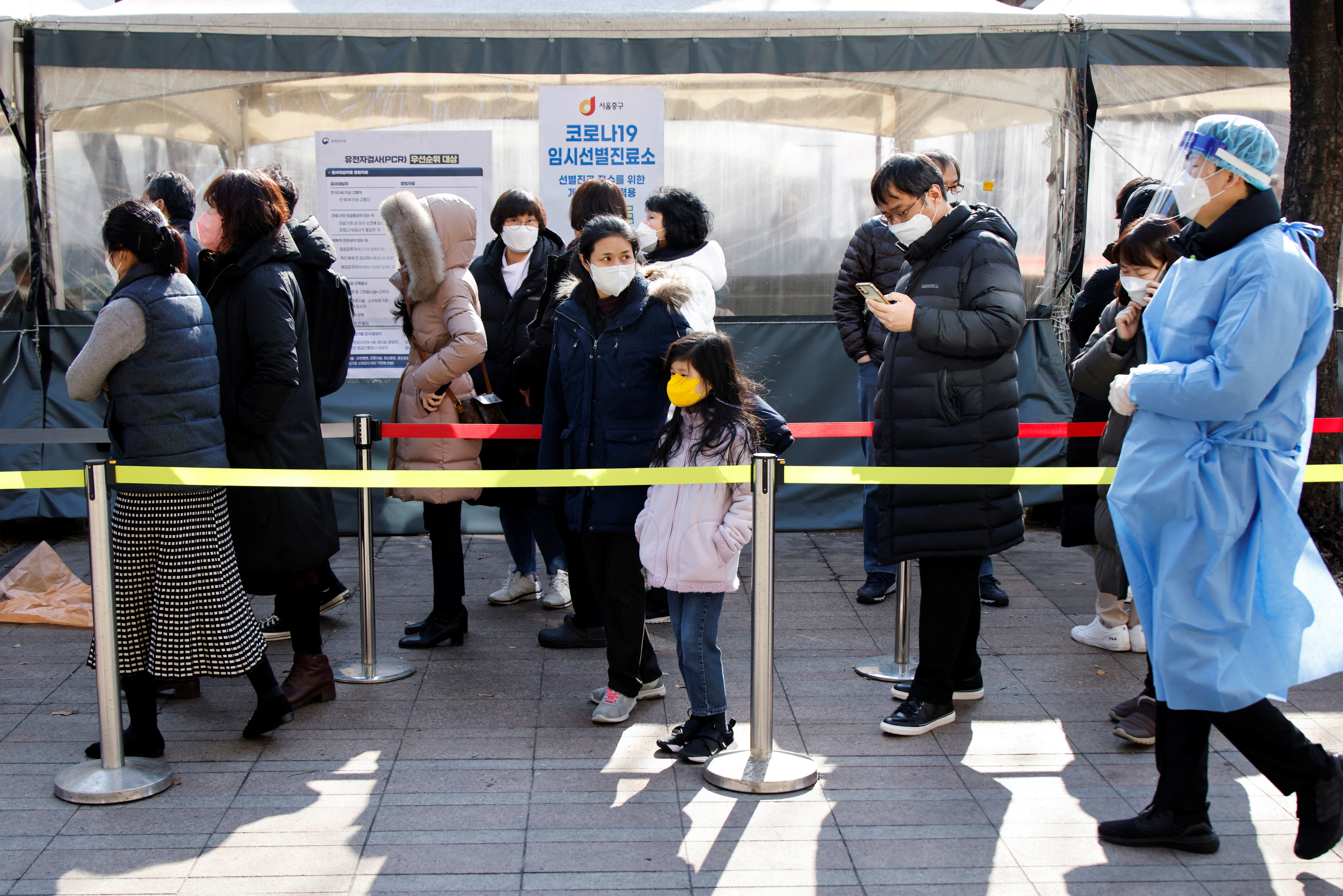 People wait in line to undergo the COVID-19 test in Seoul