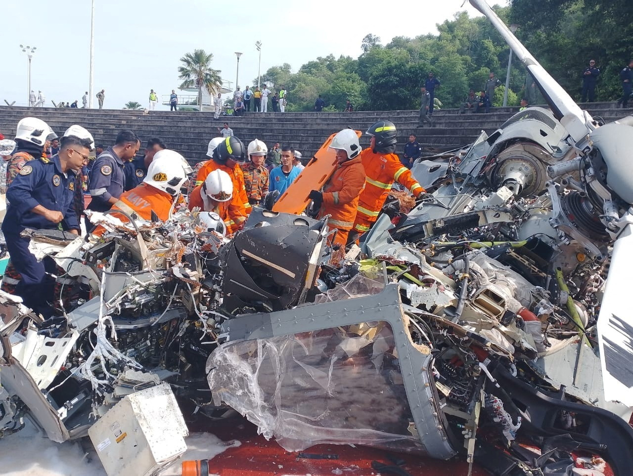 Emergency crew work at the site of a helicopter crash in Lumut, Perak