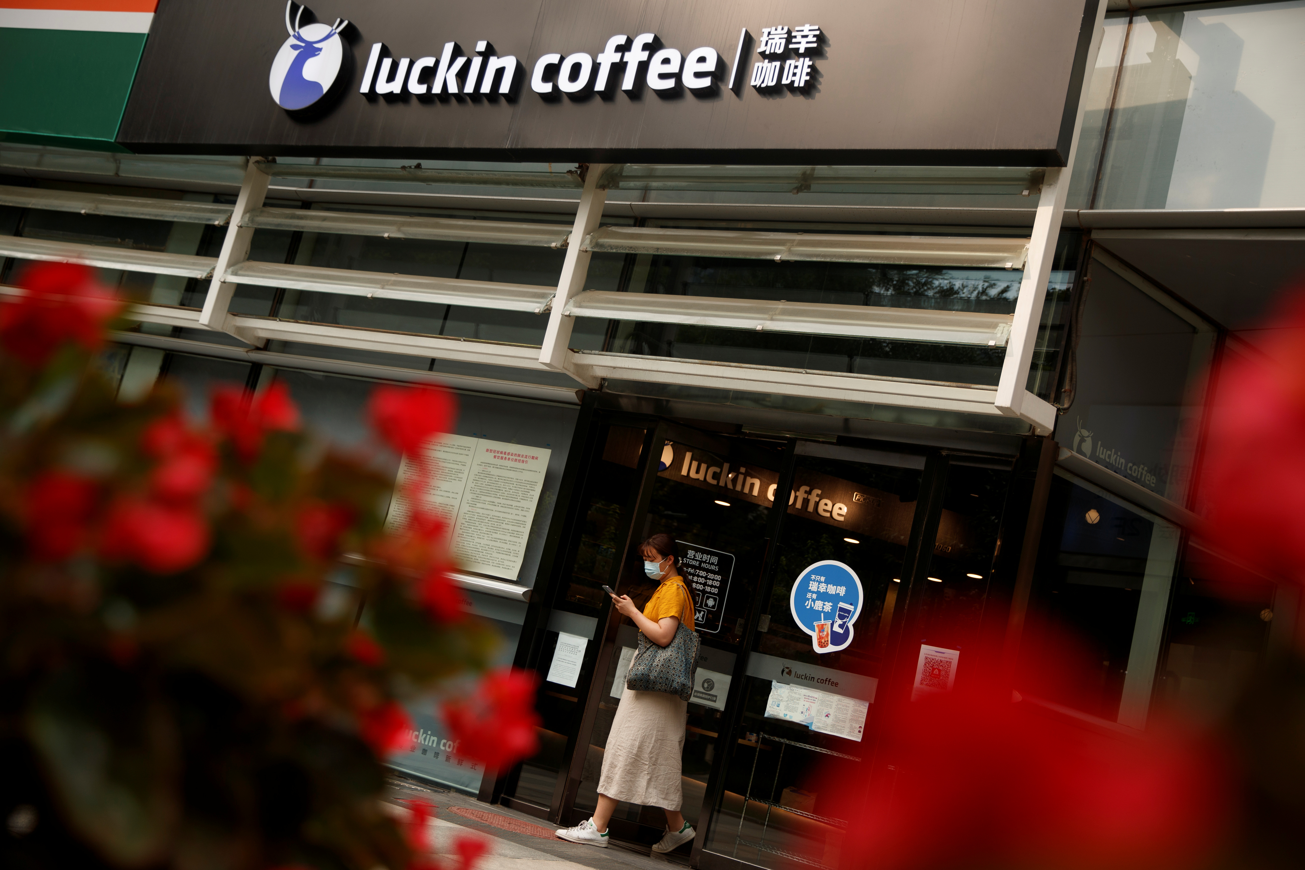 A woman leaves a store of the Chinese coffee house chain Luckin Coffee in Beijing