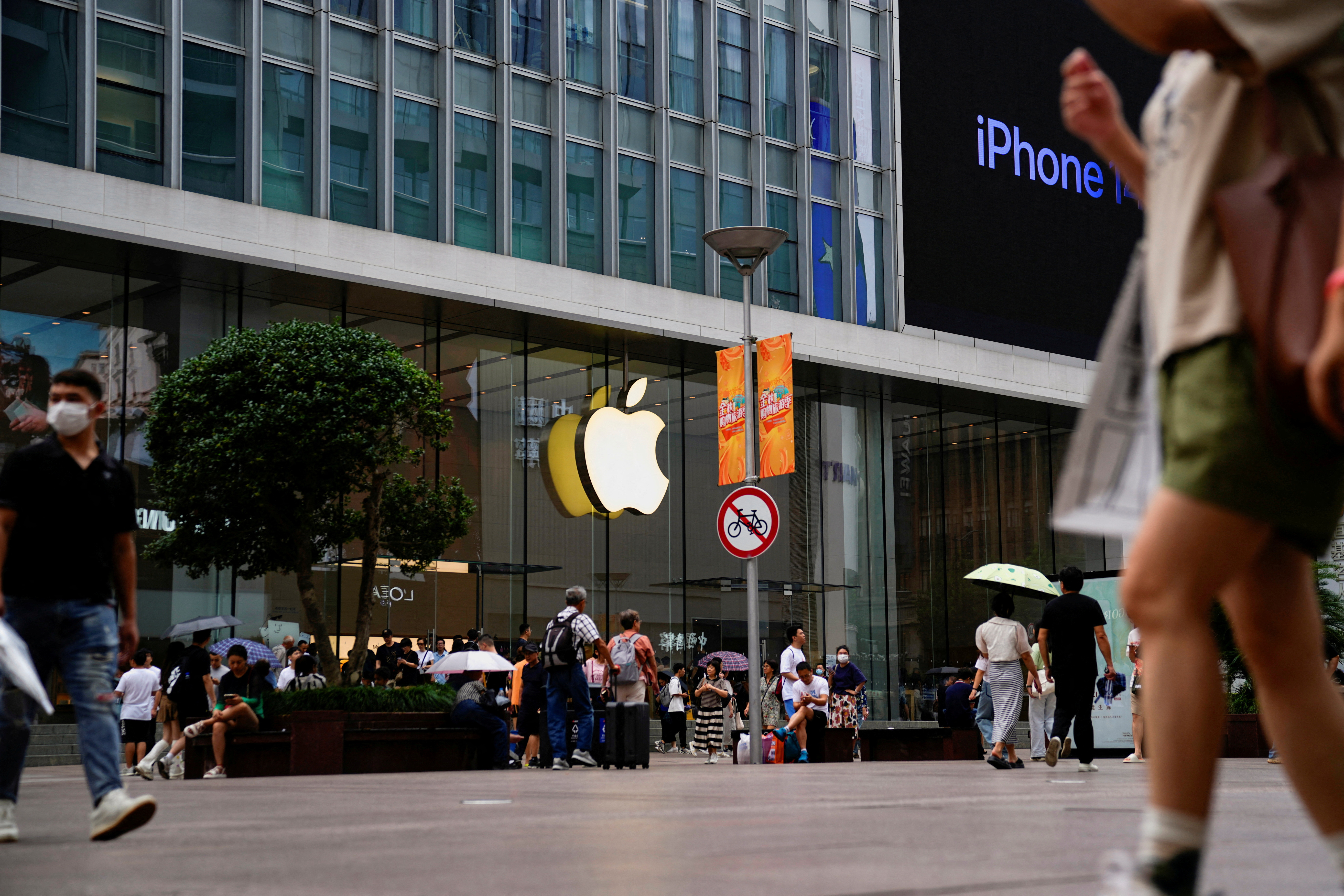 Mọi người đi ngang qua một cửa hàng Apple ở Thượng Hải
