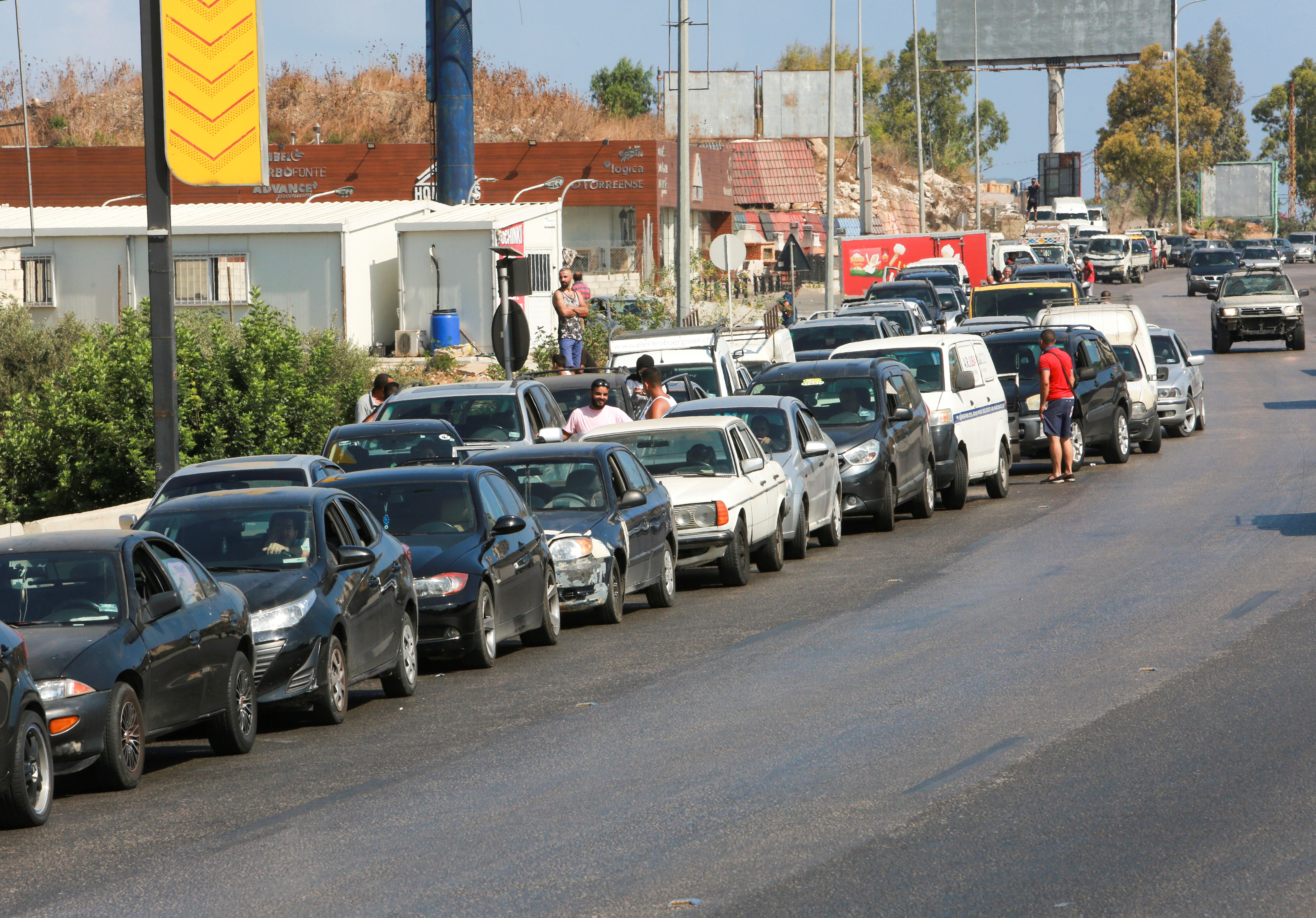Cars stand in line near a gas station as they wait to fuel up in Jiyeh