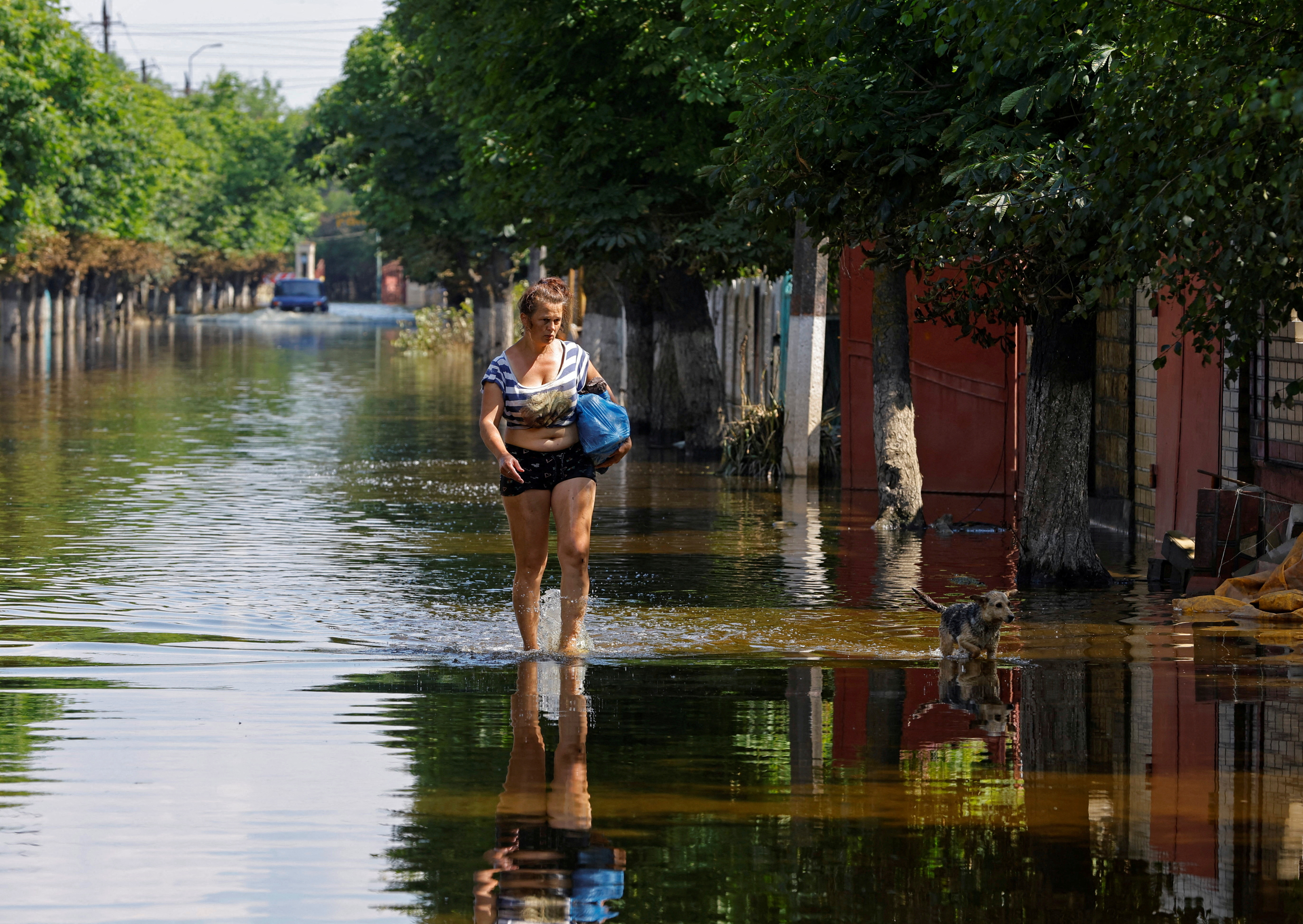 A woman walks along a street after floodwaters receded in Hola Prystan