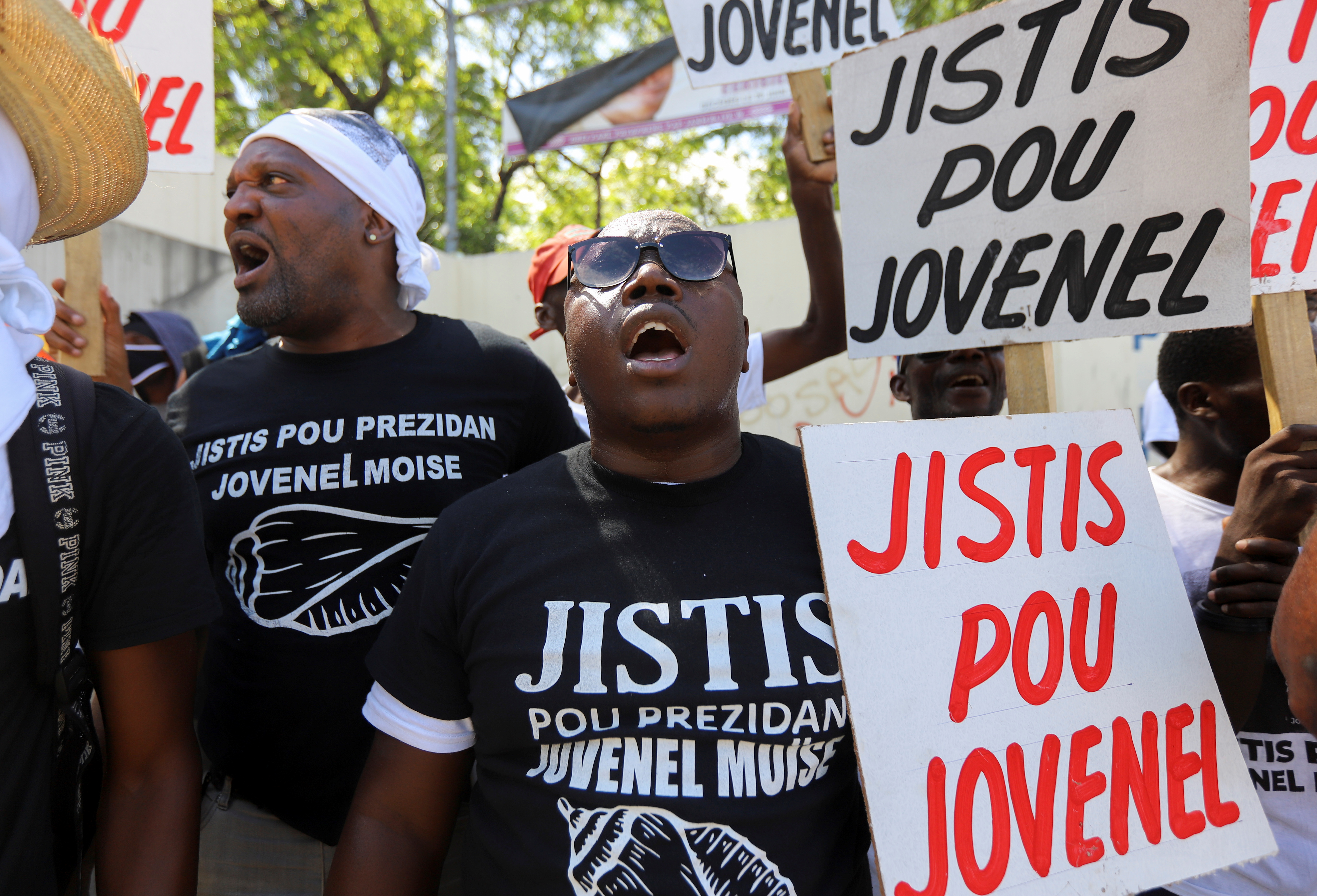 Demonstrators hold signs reading "Justice for Jovenel" outside a judicial hearing into the assassination of President Jovenel Moise attended by former first lady Martine Moise, in Port-au-Prince, Haiti October 6, 2021. REUTERS/Ralph Tedy Erol