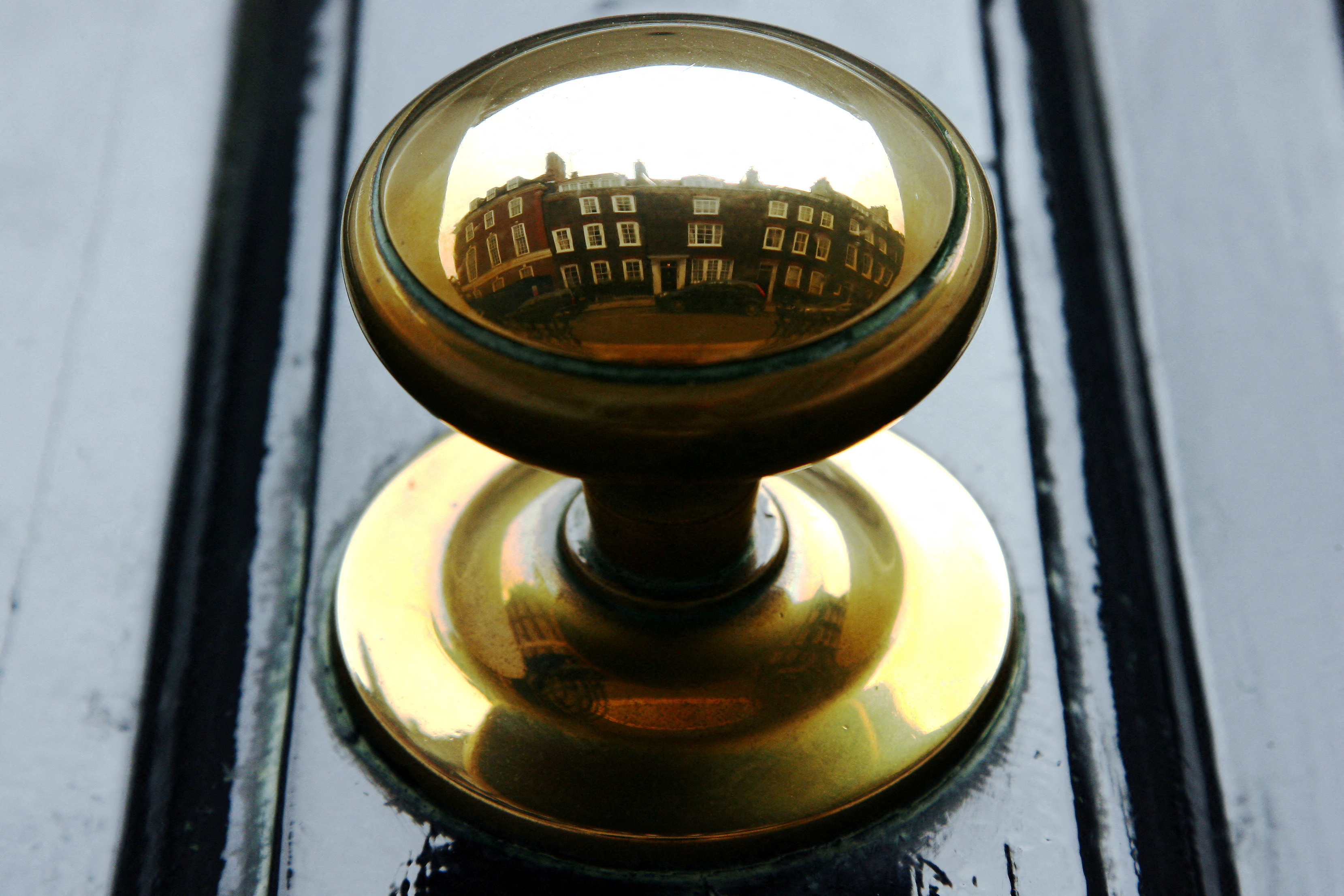 Houses are reflected in the door handle of a property in central London