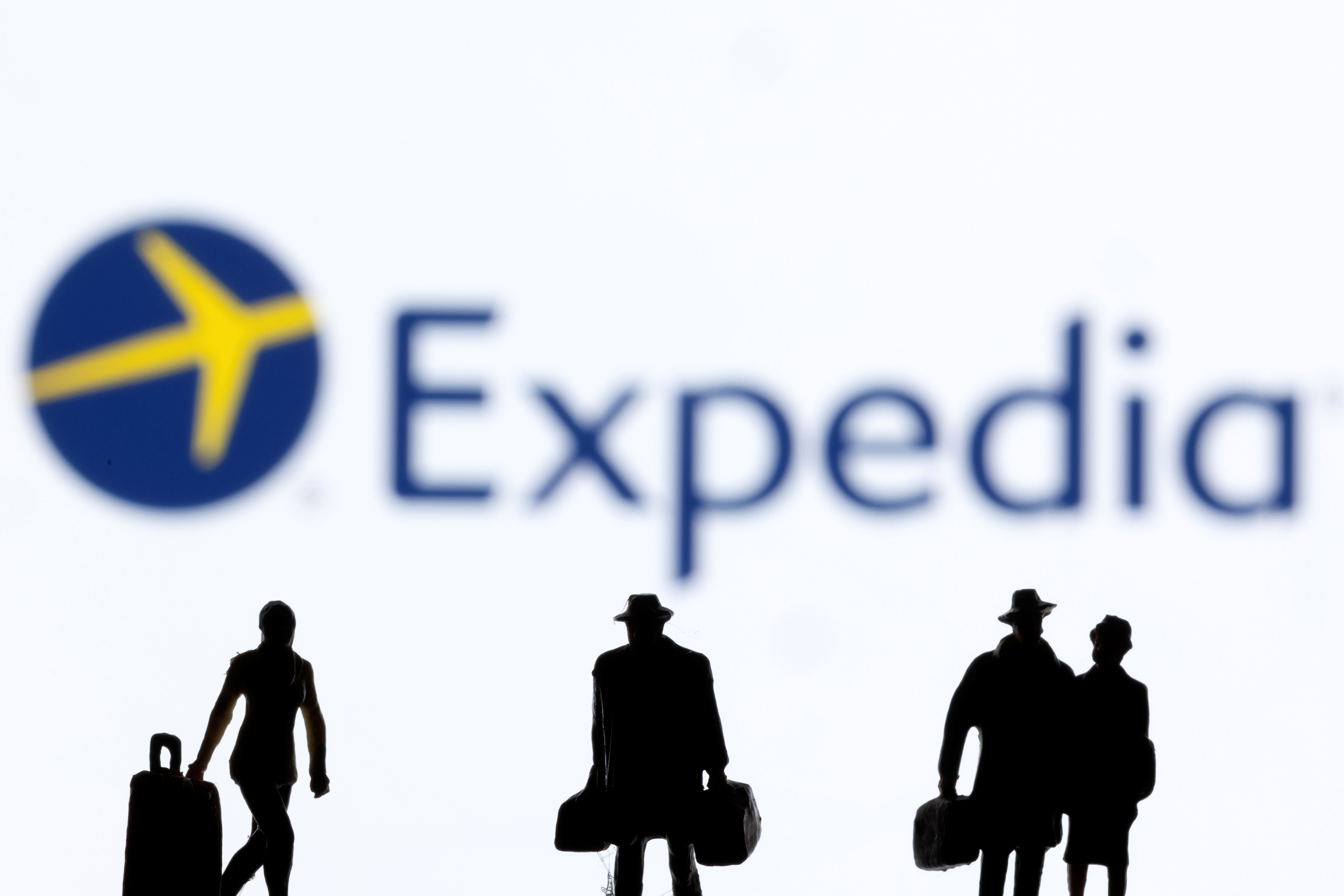 Figurines are seen in front of Expedia logo