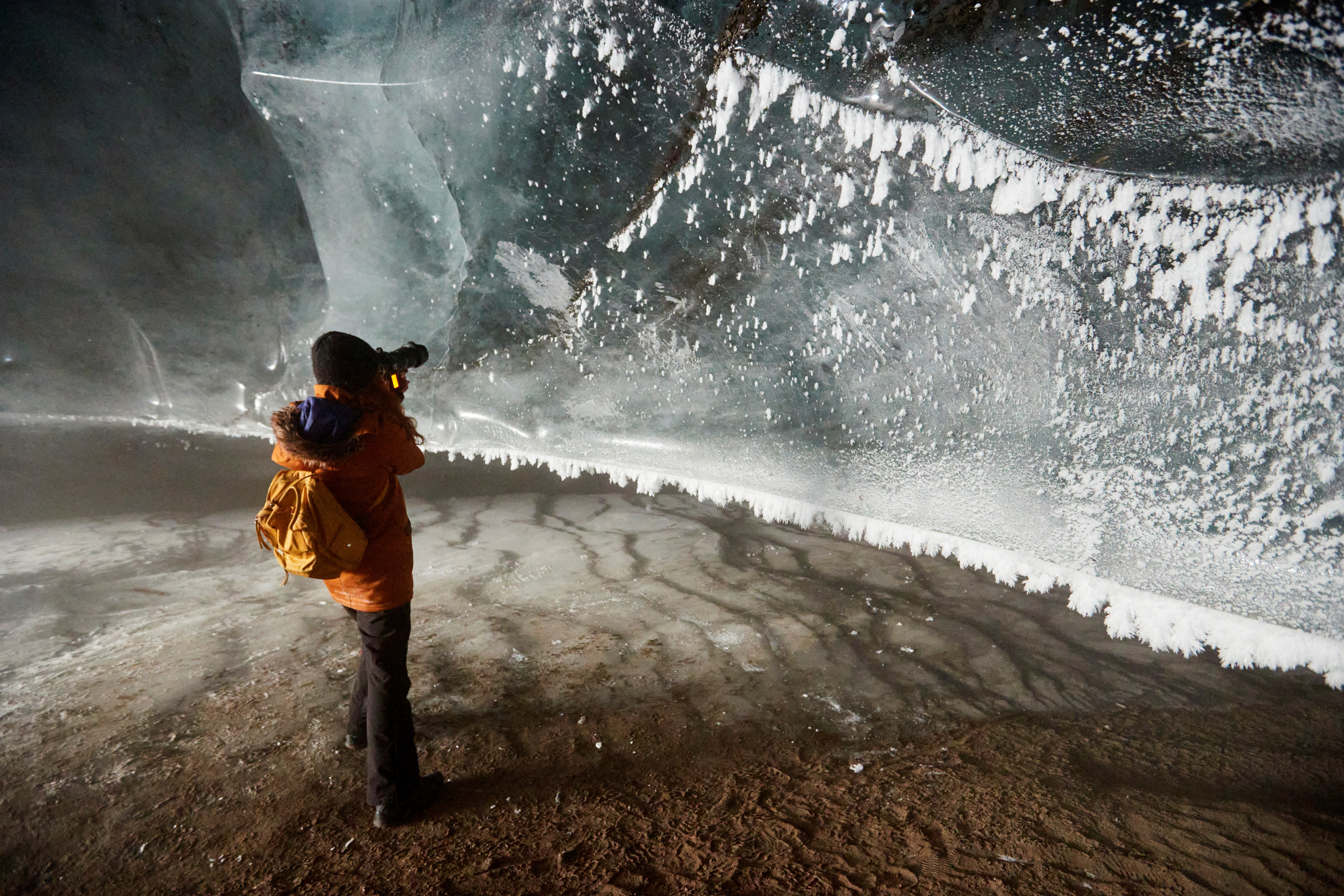 Photographer takes a picture in the ice cave at the Glacier 3000 ski resort in Les Diablerets