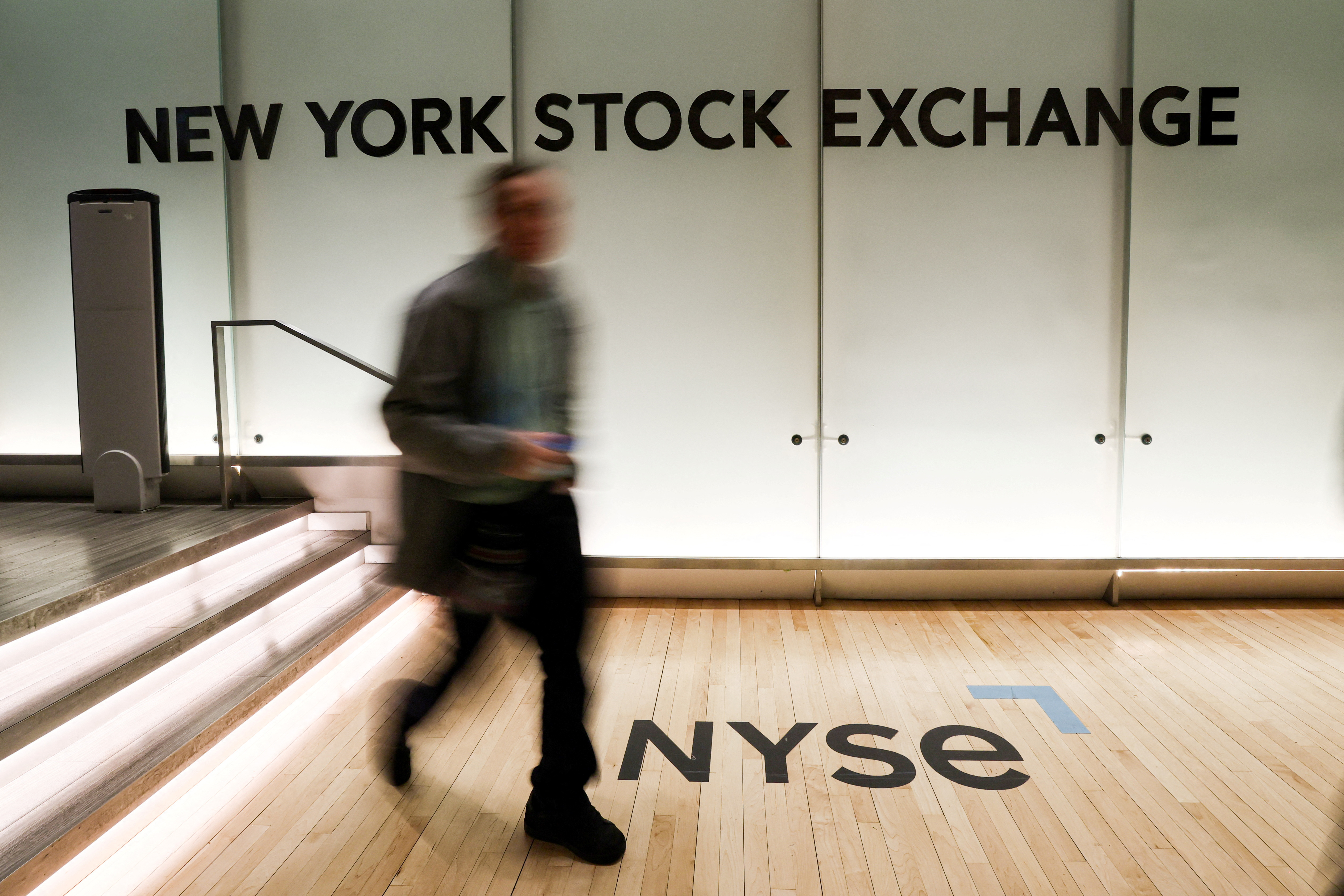 A trader walks on the trading floor of the NYSE in New York