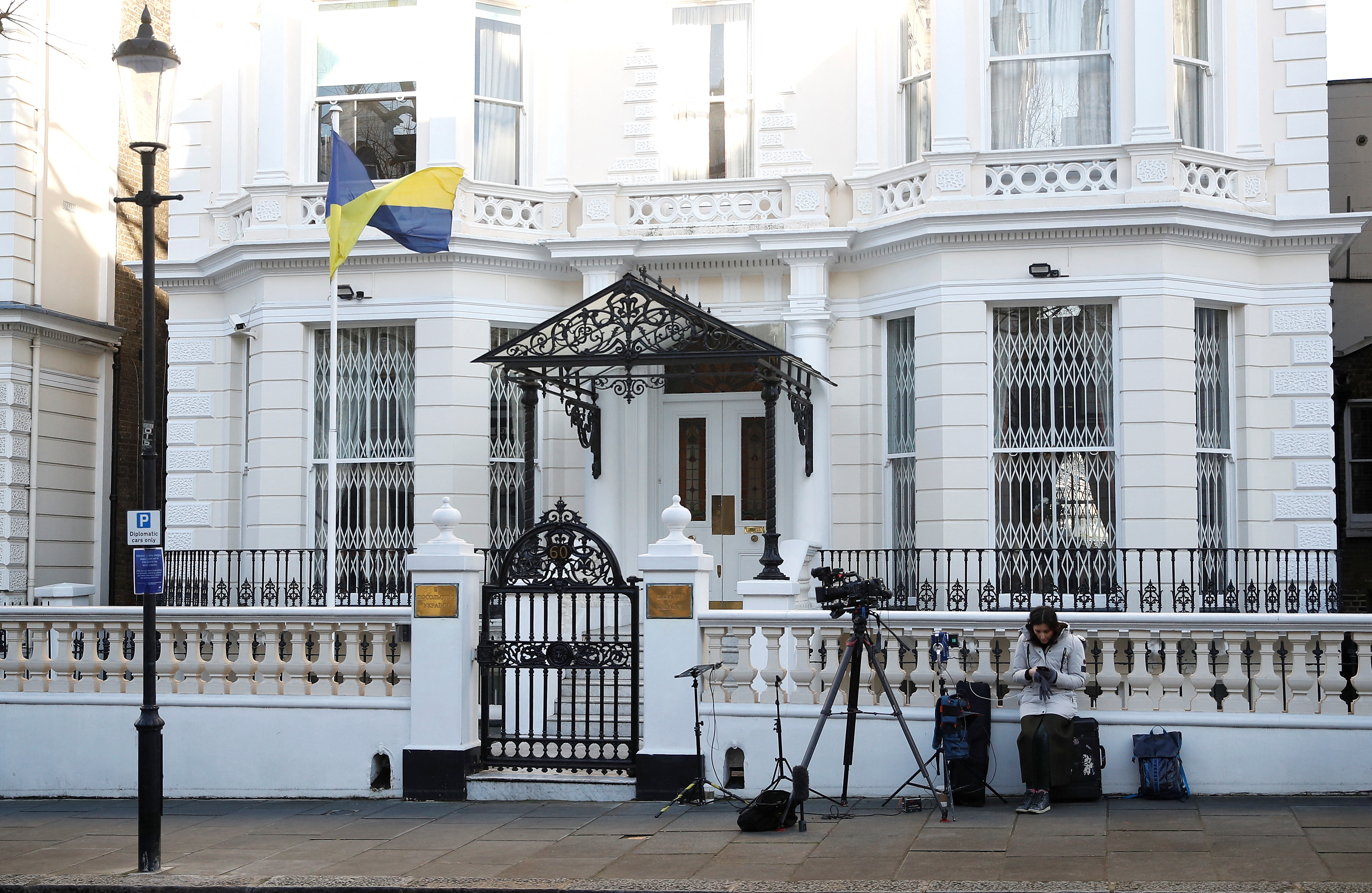 A television journalist waits outside the Ukraine embassy in London