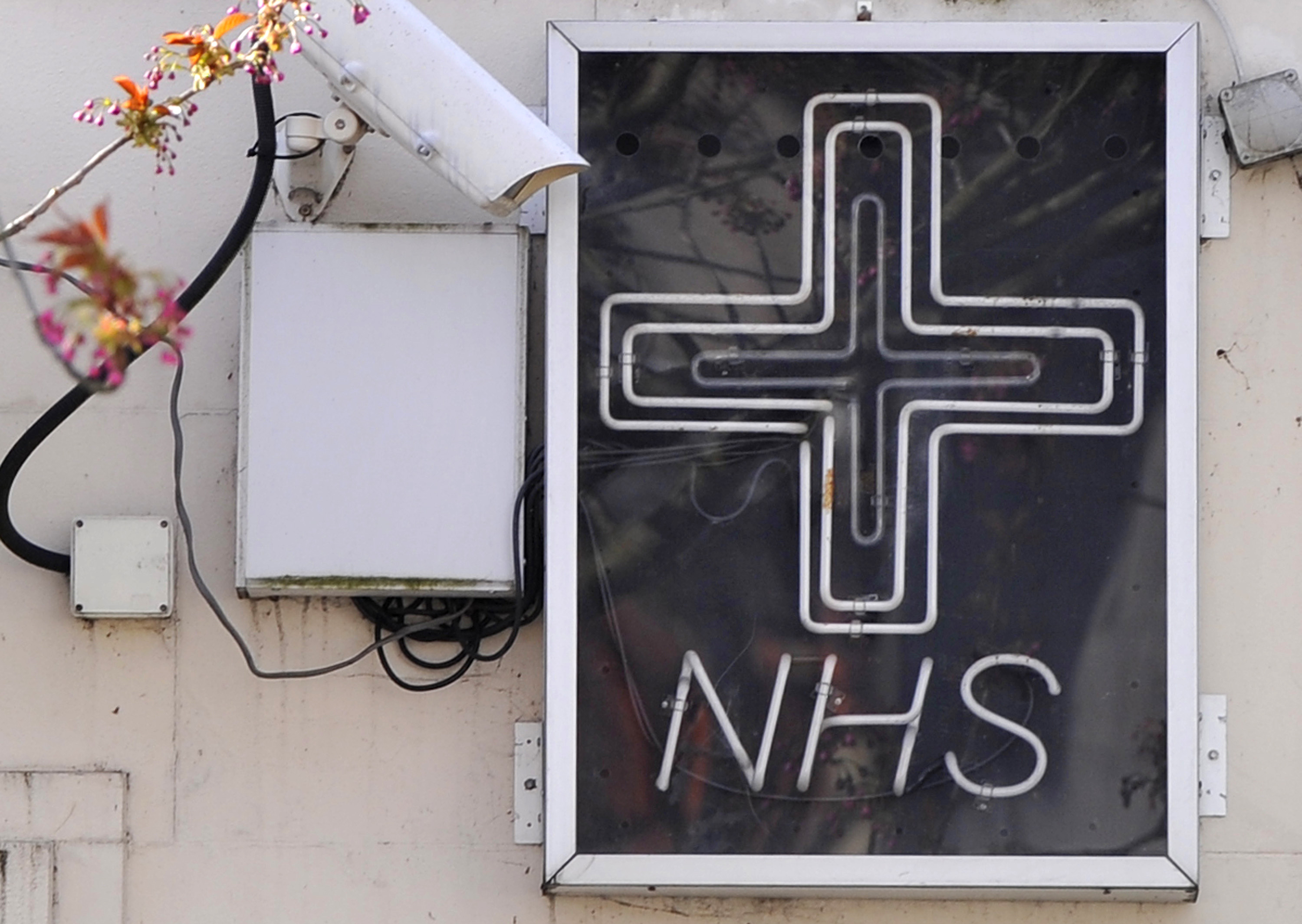 An NHS sign is seen outside a pharmacy in London