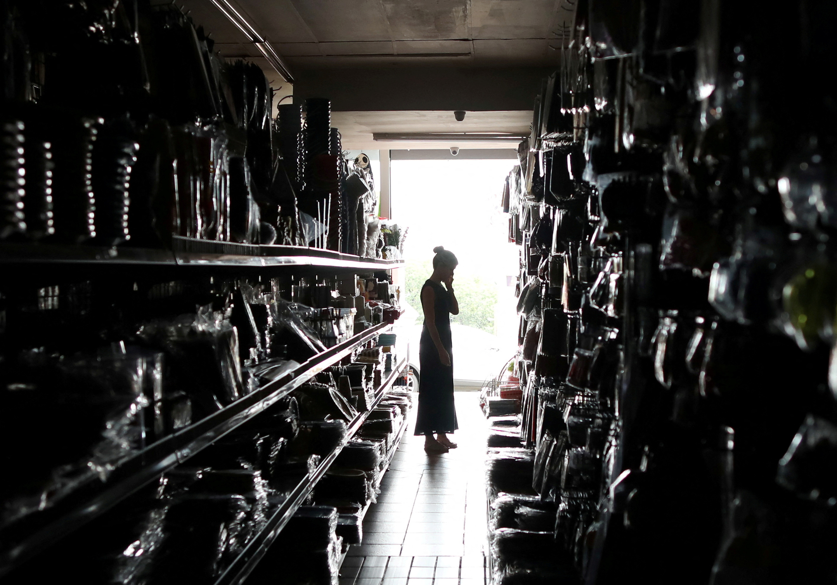 A shopper looks for goods during an electricity load-shedding blackout in Johannesburg