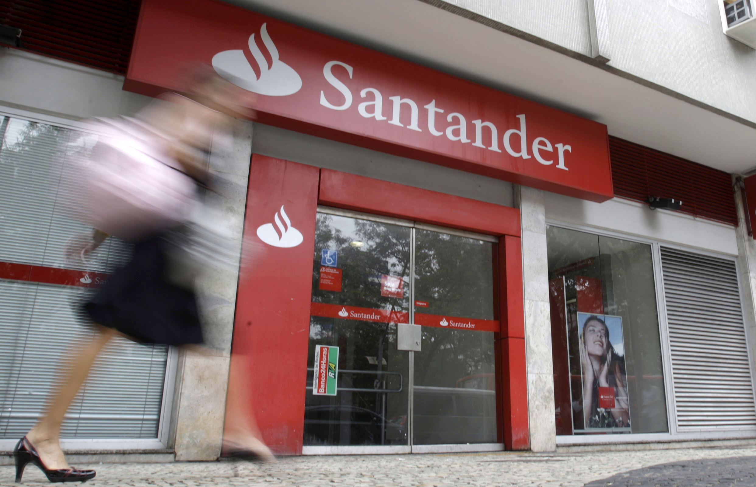 A woman walks past Santander bank branch in Rio de Janeiro