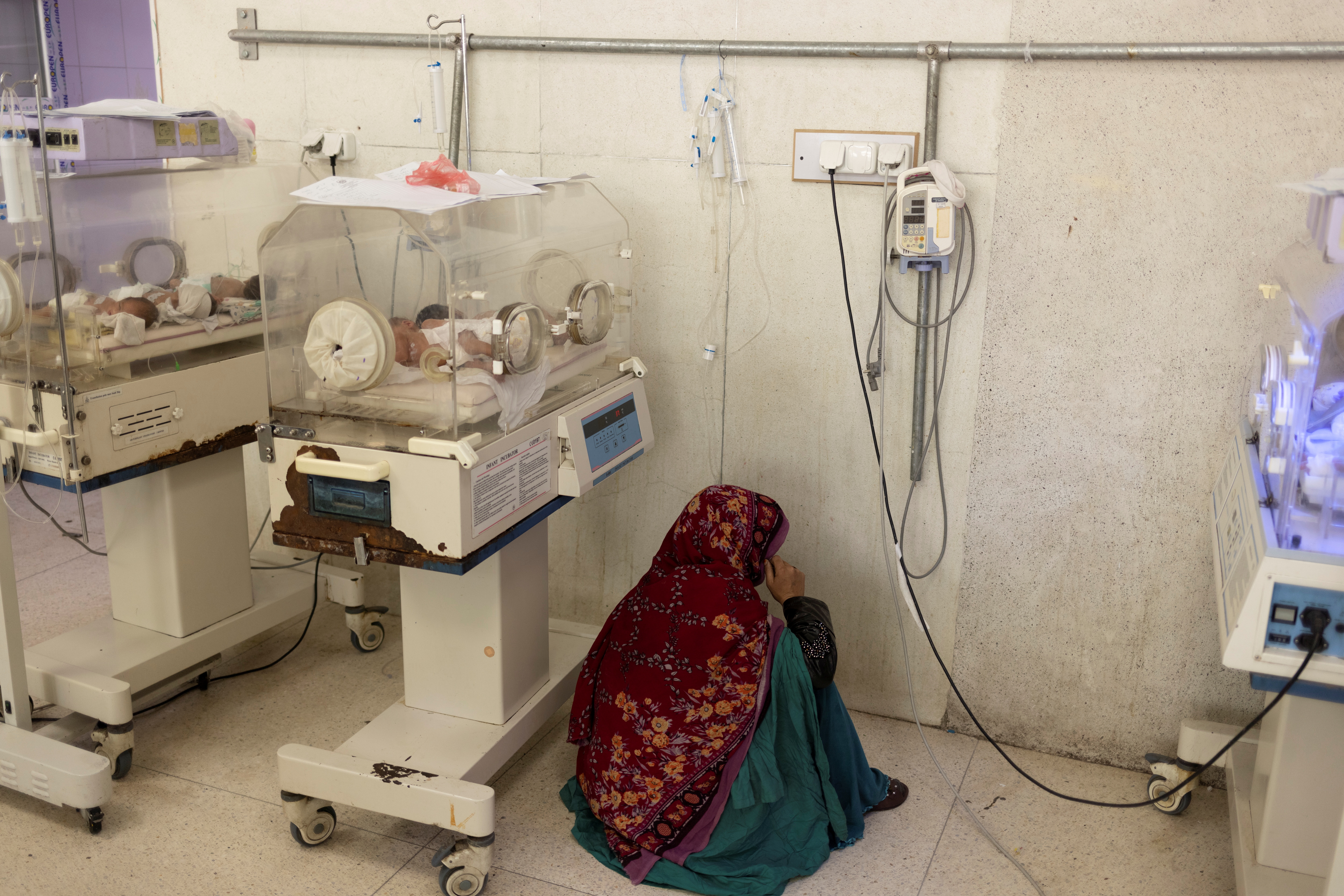 A woman sits next to an incubator at the premature infants ward at the Indira Gandhi hospital in Kabul