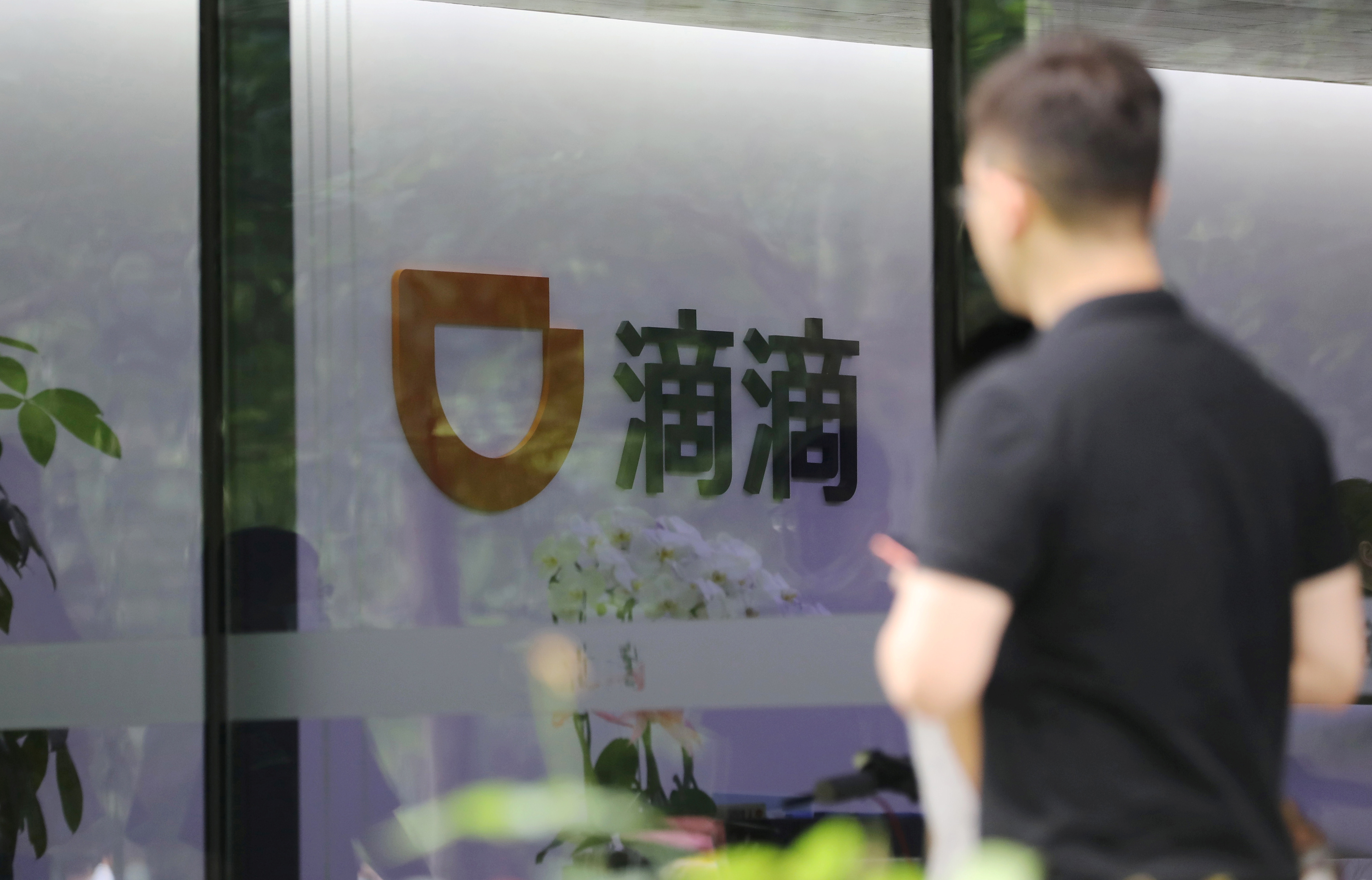 Man walks past the headquarters building of Chinese ride-hailing service Didi in Beijing