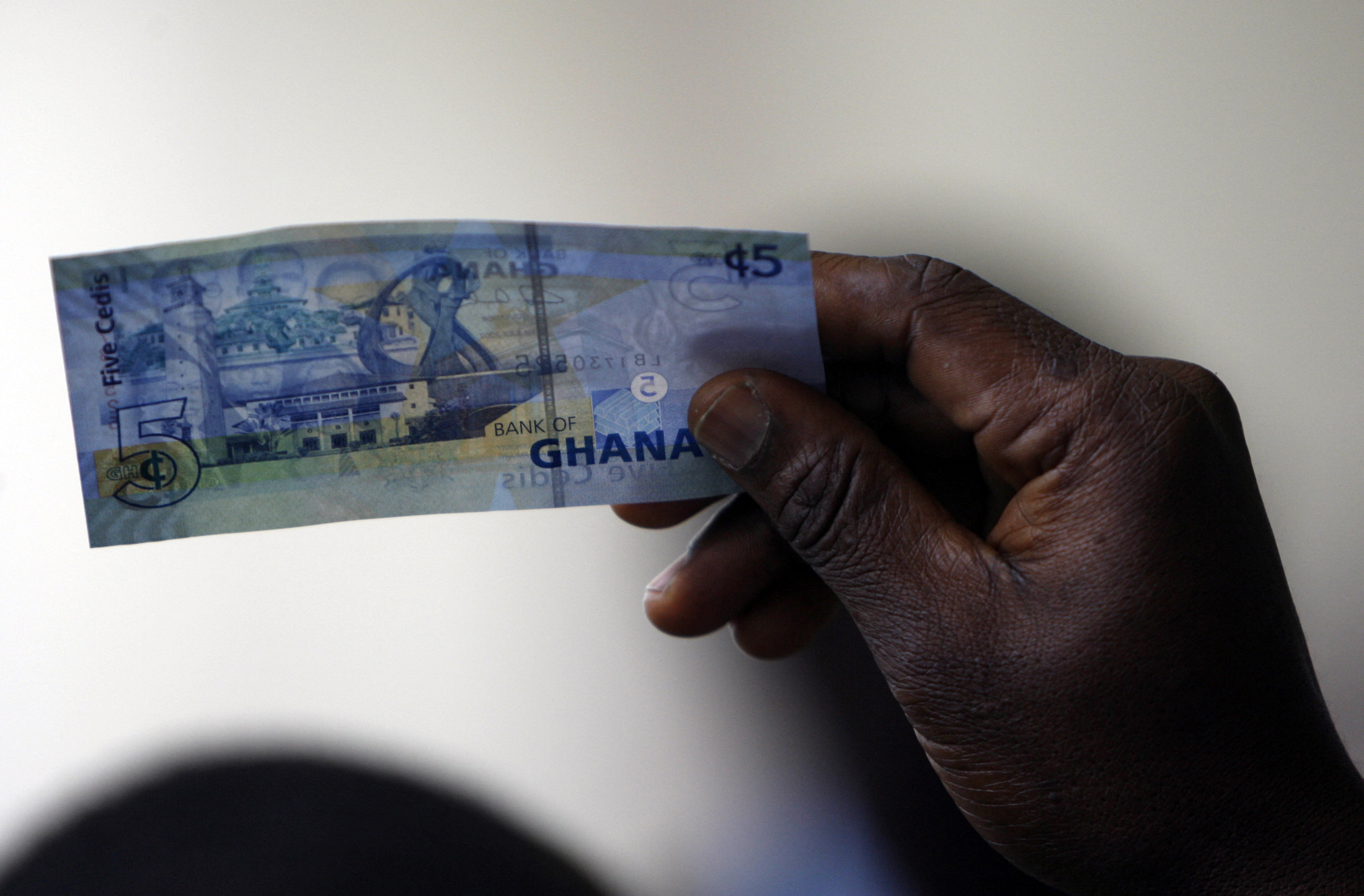 A man holds a Ghanaian five cedi note in Accra