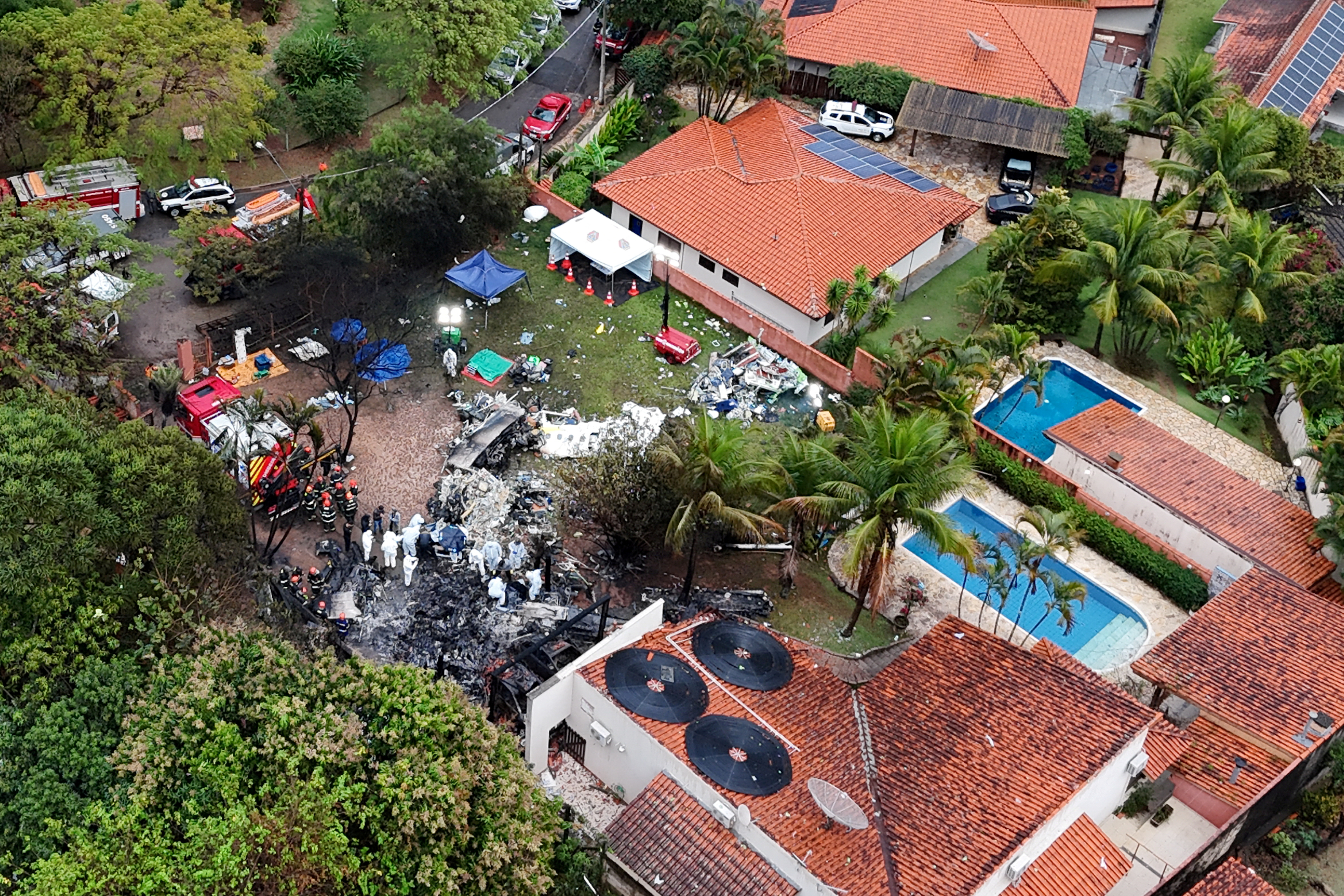 Officials work at the site of a plane crash in Vinhedo, Sao Paulo