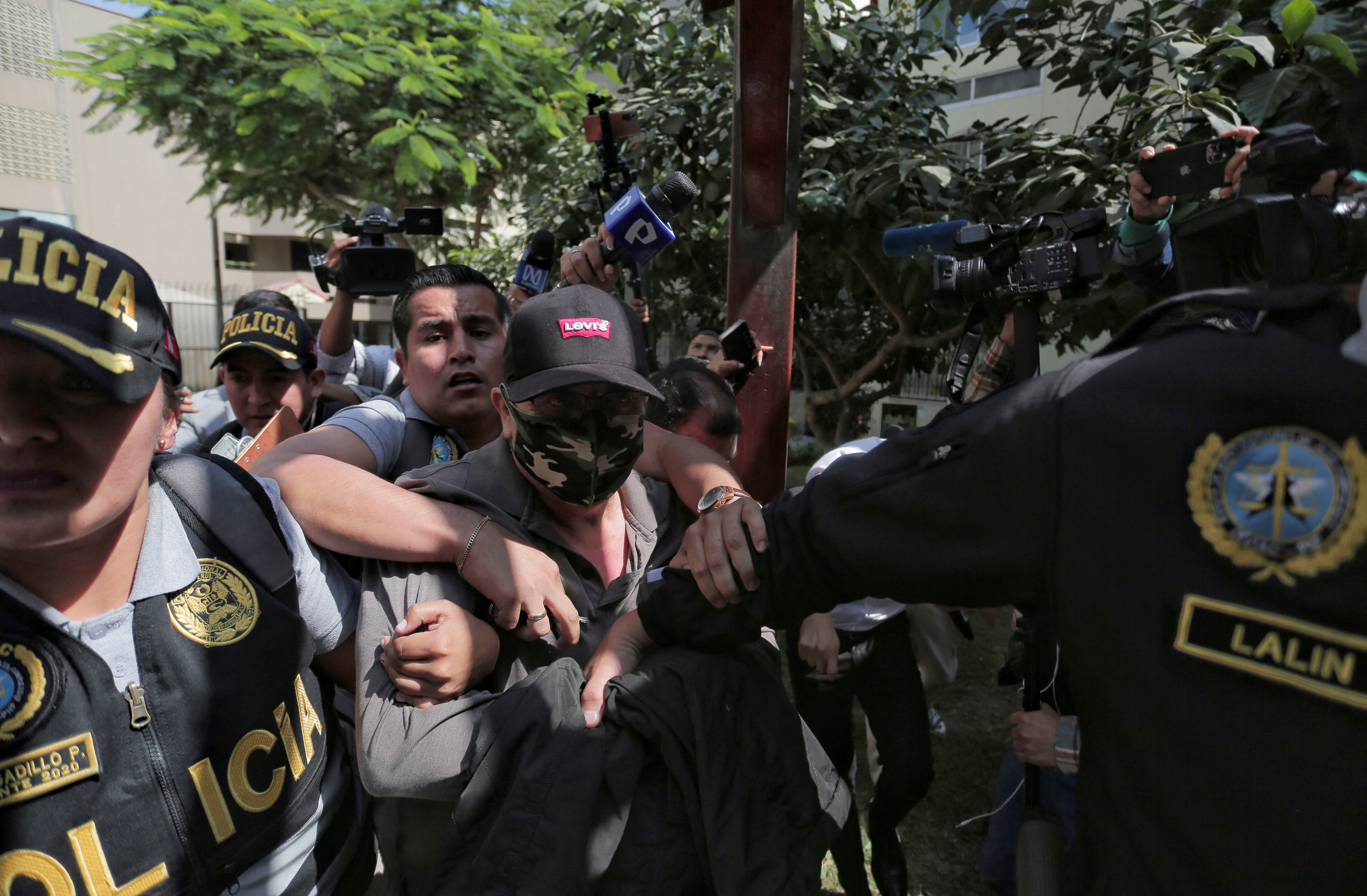 Police officers escort Nicanor Boluarte, brother of Peruvian President Dina Boluarte, in Lima