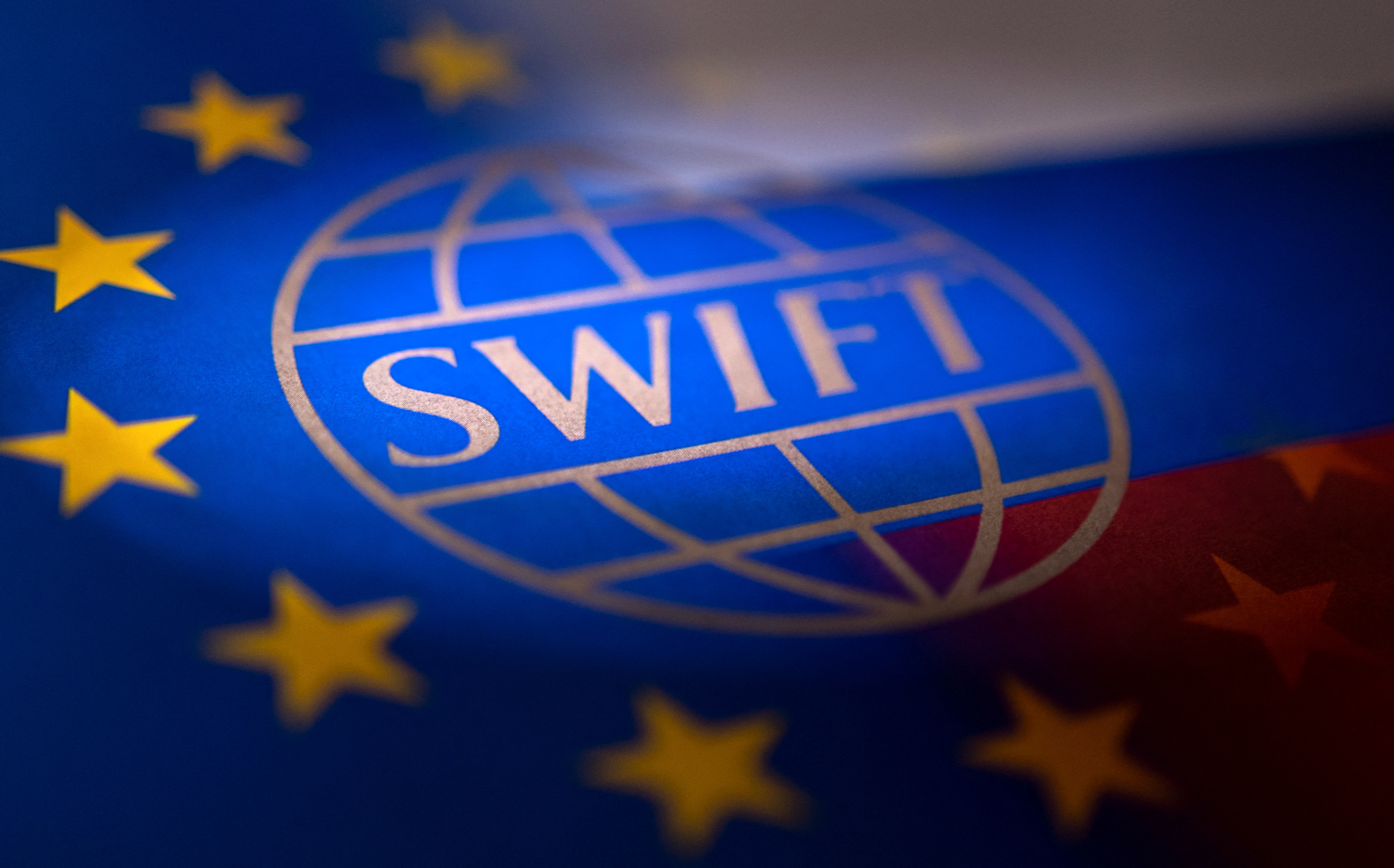Illustration shows Swift logo, EU and Russian flags