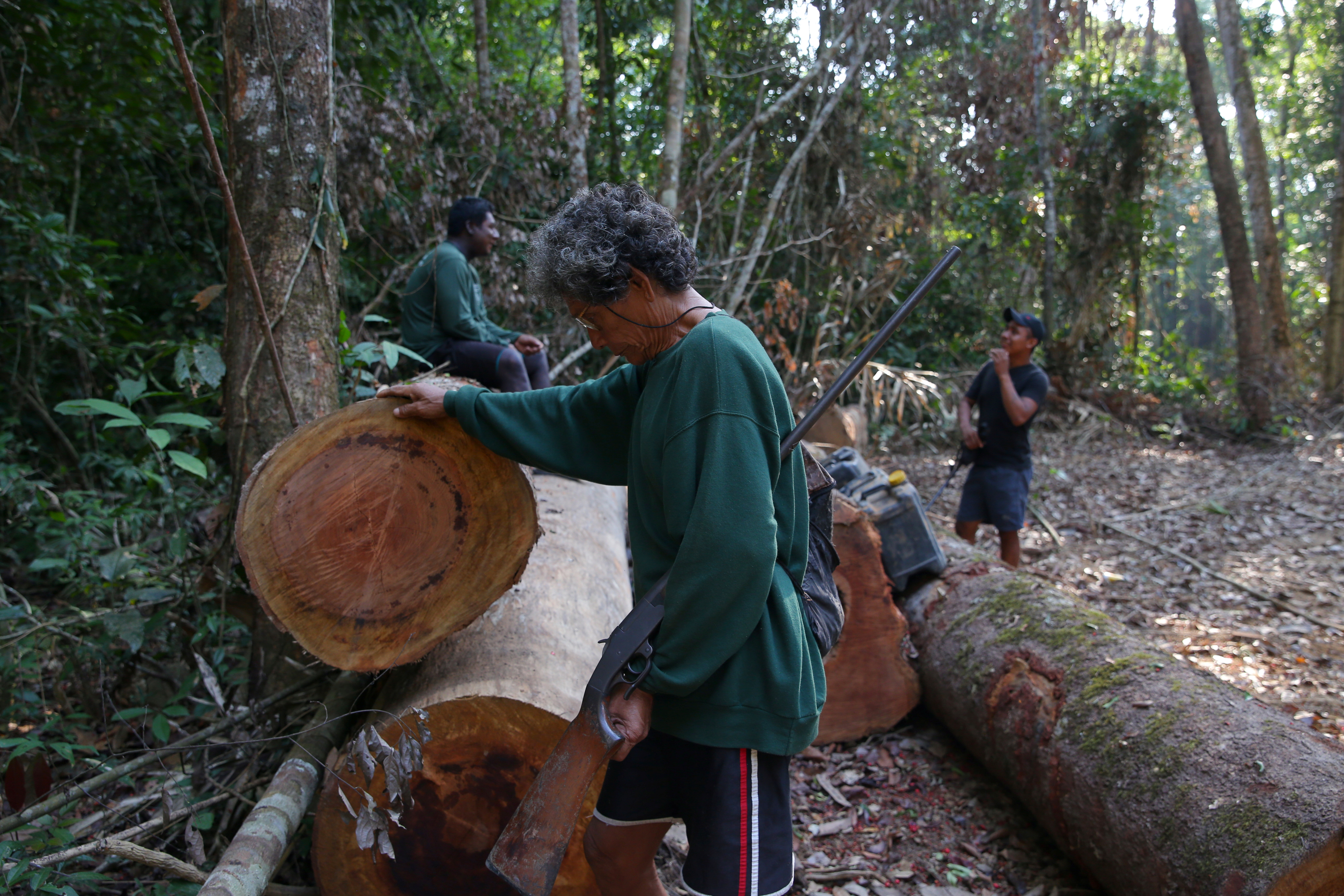 Kayapo indigenous men inspect tree logs left by loggers who fled as they where doing a surveillance patrol three weeks ago on Bau indigenous land in the Amazon near Novo Progresso