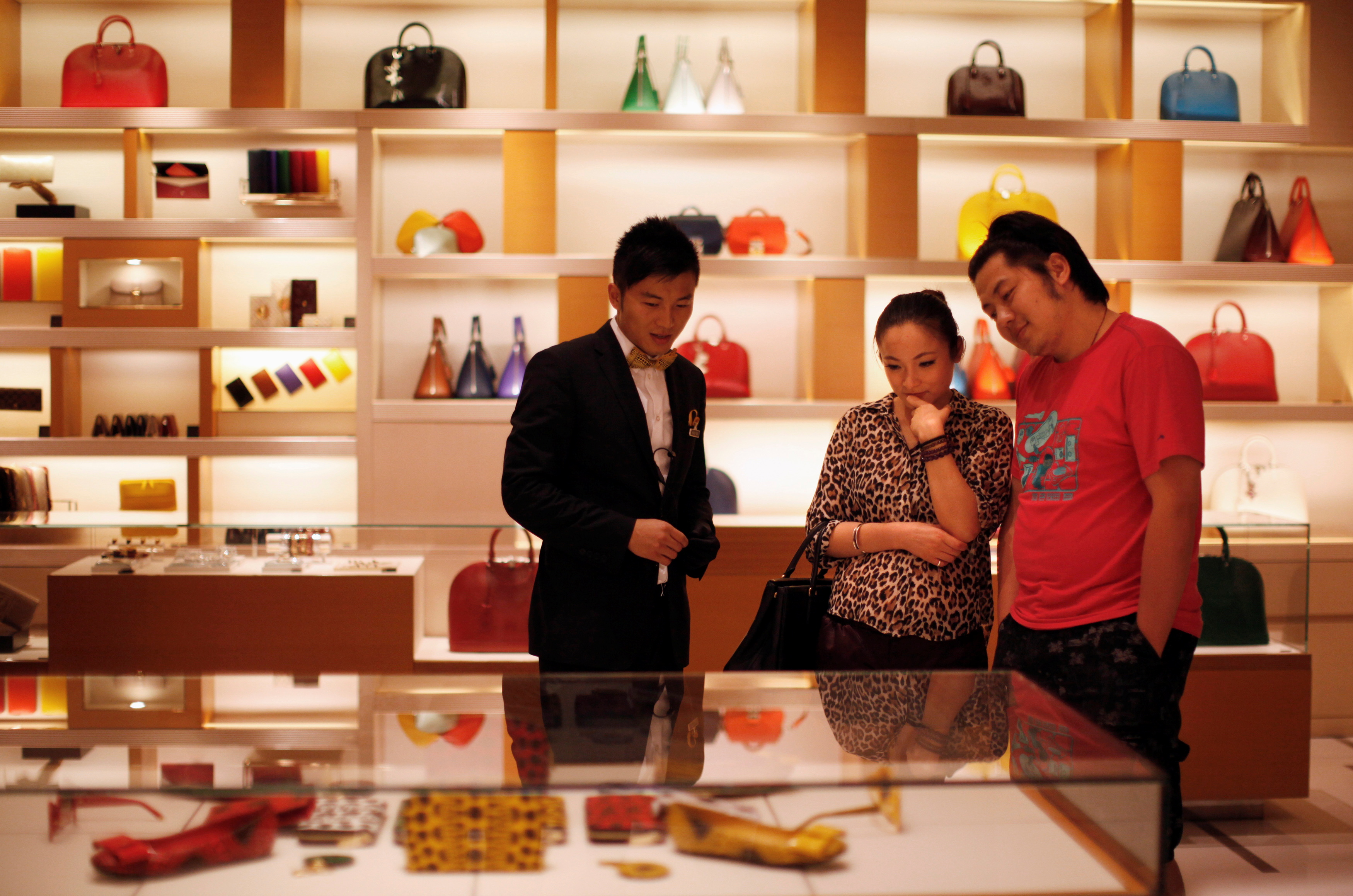 A couple shop at a Louis Vuitton store during Vogue's 4th Fashion's Night Out: Shopping Night with Celebrities in downtown Shanghai