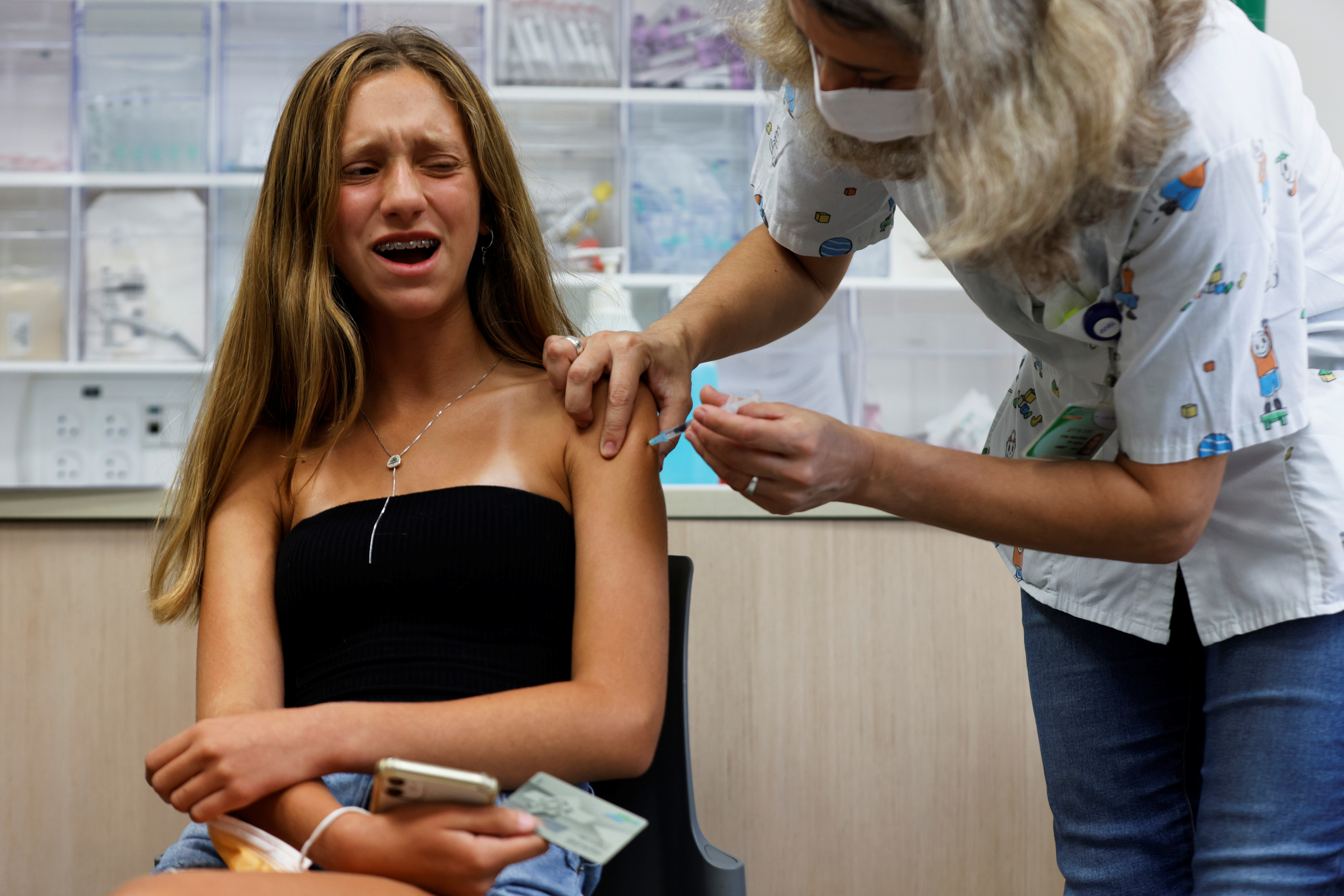 A teenager reacts while receiving a dose of a vaccine against the coronavirus disease (COVID-19) in Tel Aviv