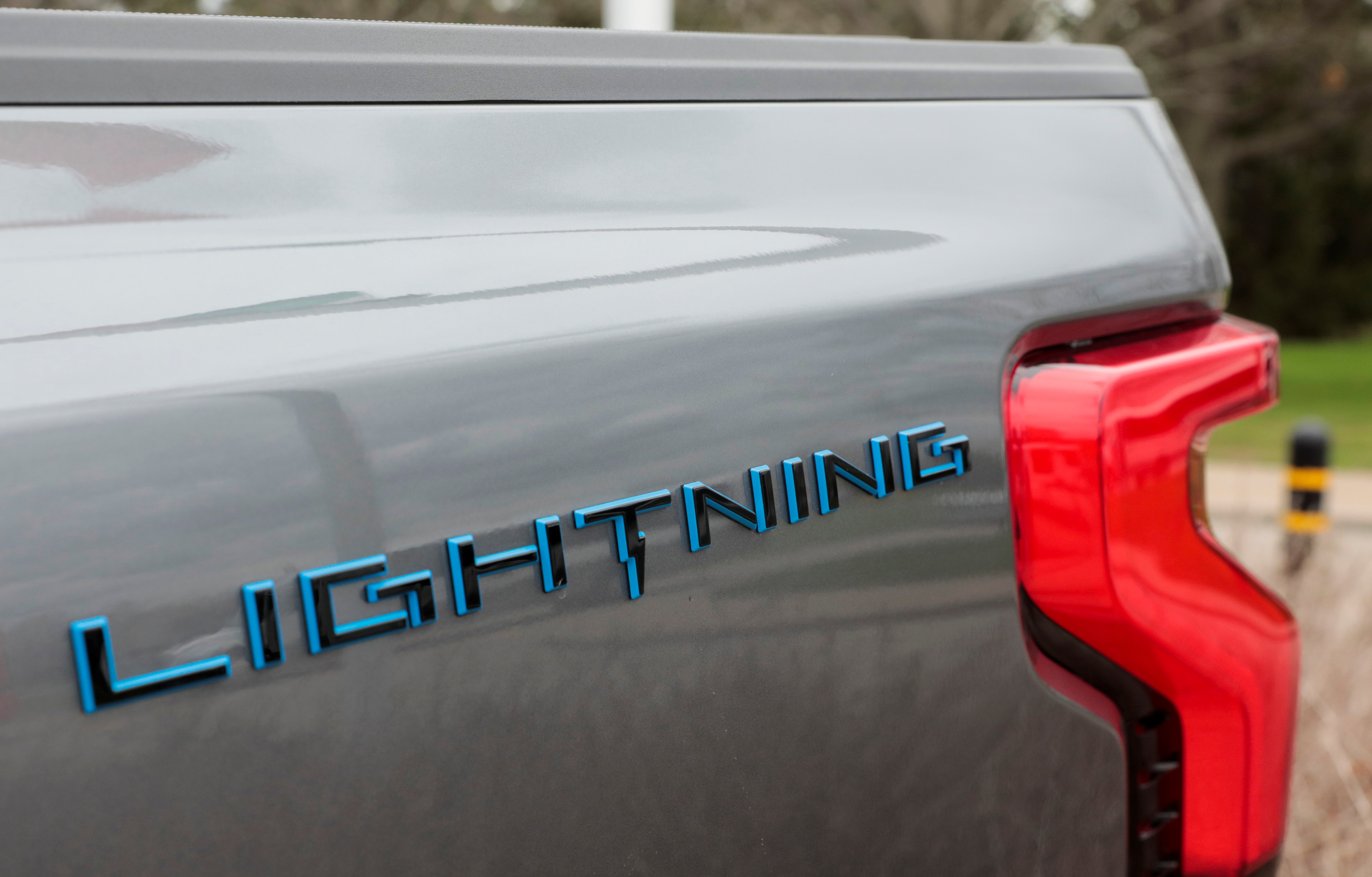 The Lightning logo is seen on the side of an all-new Ford F-150 Lightning electric pickup truck