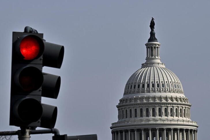 Red light traffic signal is seen with the dome of the U.S. Capitol building in the distance, in Washington