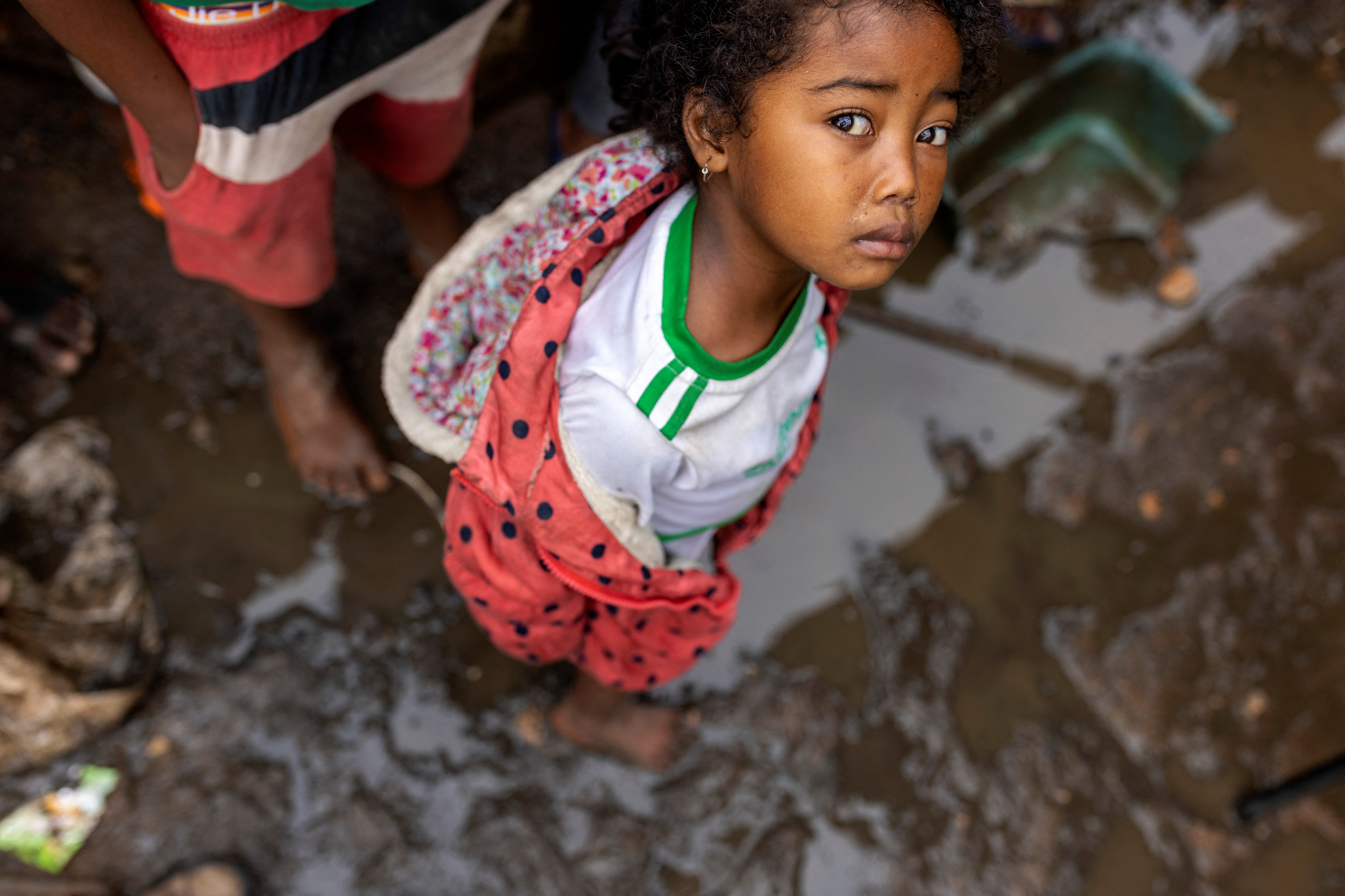 A girl stands at a muddy alley of the neighbourhood of West Ankorondrano, which was previously flooded by Cyclone Ana, as Cyclone Batsirai is expected to hit Madagascar, in Antananarivo, Madagascar, February 5, 2022. REUTERS/Alkis Konstantinidis
