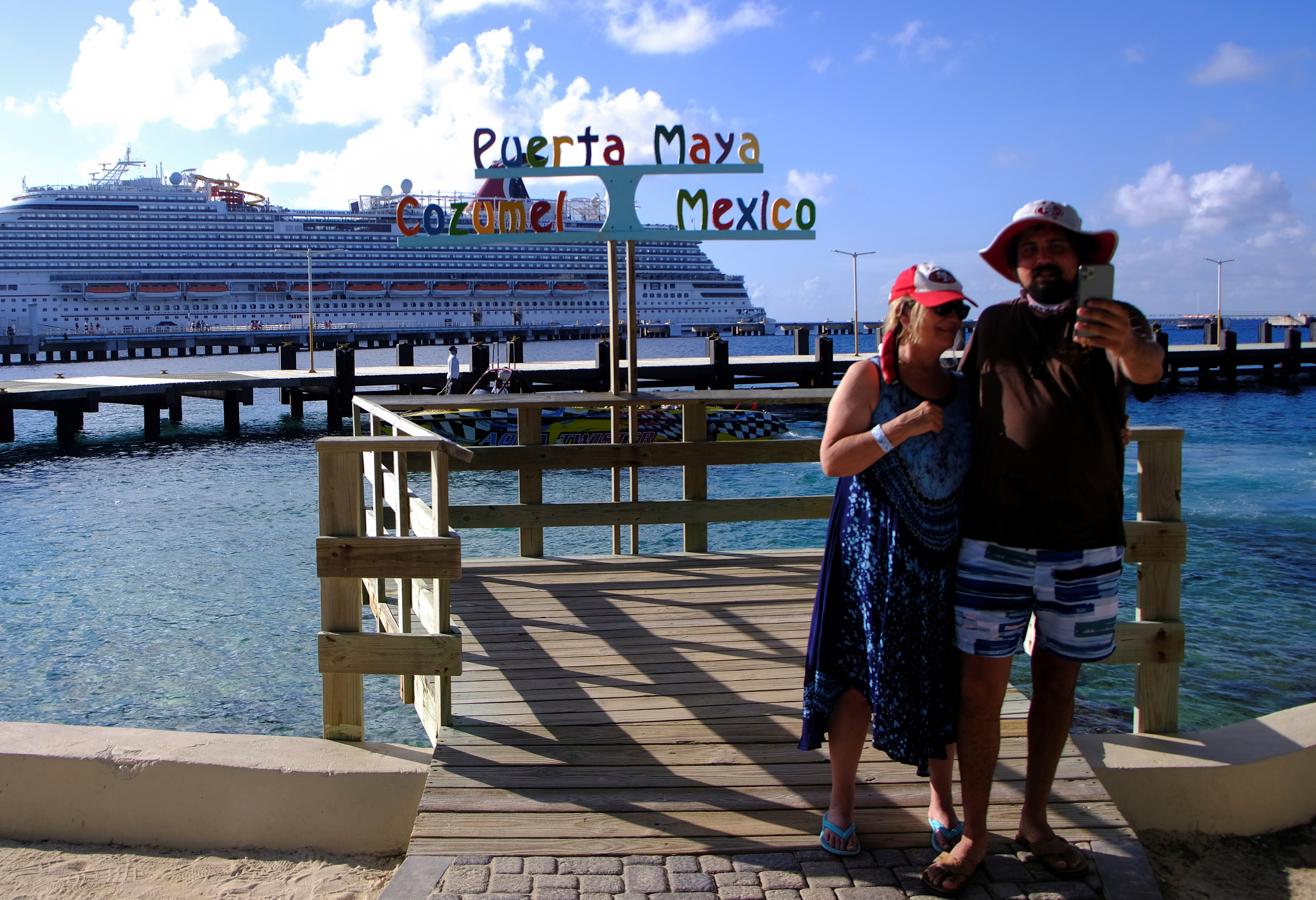 A couple takes a picture in front of a cruise ship amid the spread of the coronavirus disease (COVID-19), in Cozumel, Mexico December 6, 2021. REUTERS/Paola Chiomante