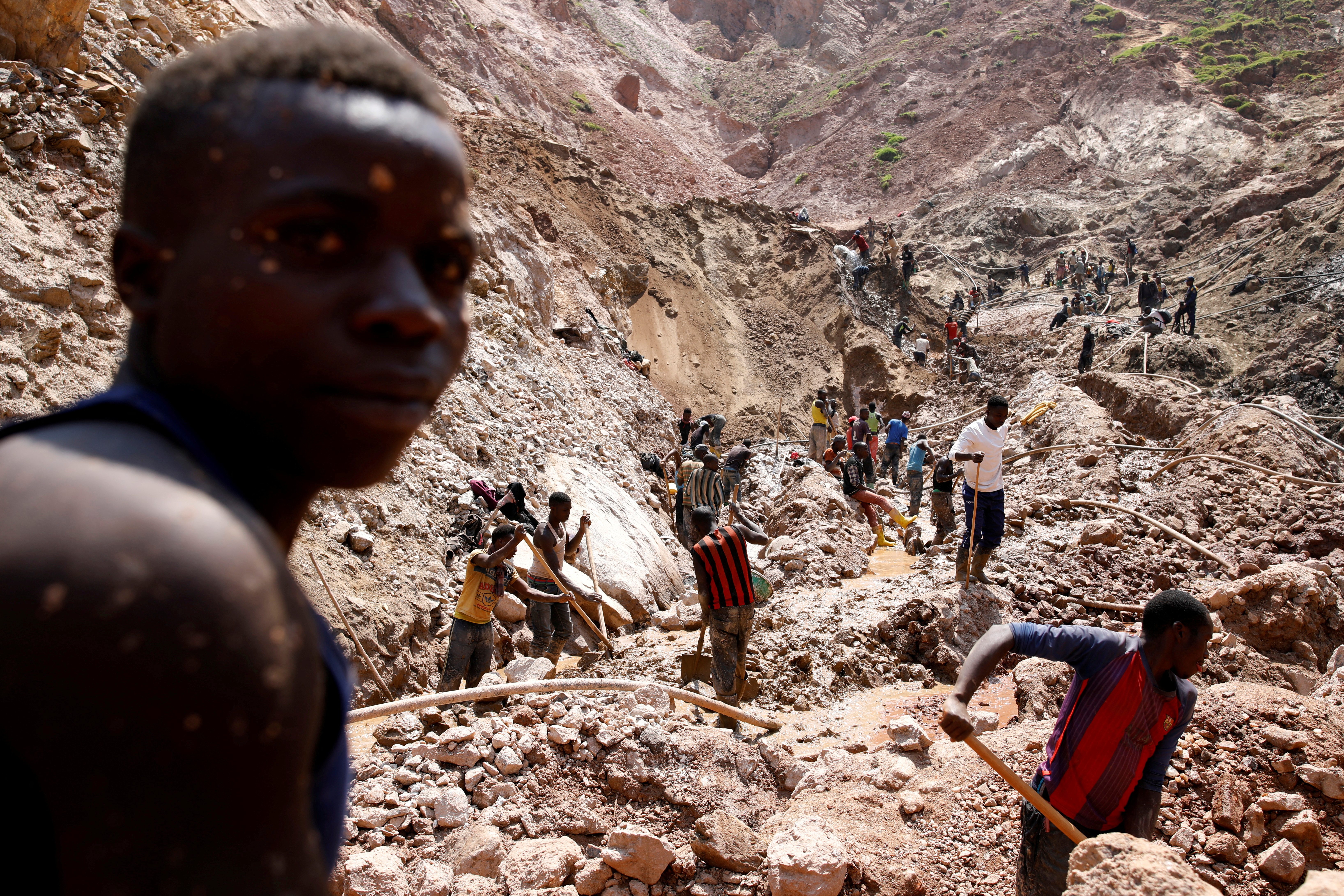Labourers work at an open shaft of the SMB coltan mine near the town of Rubaya