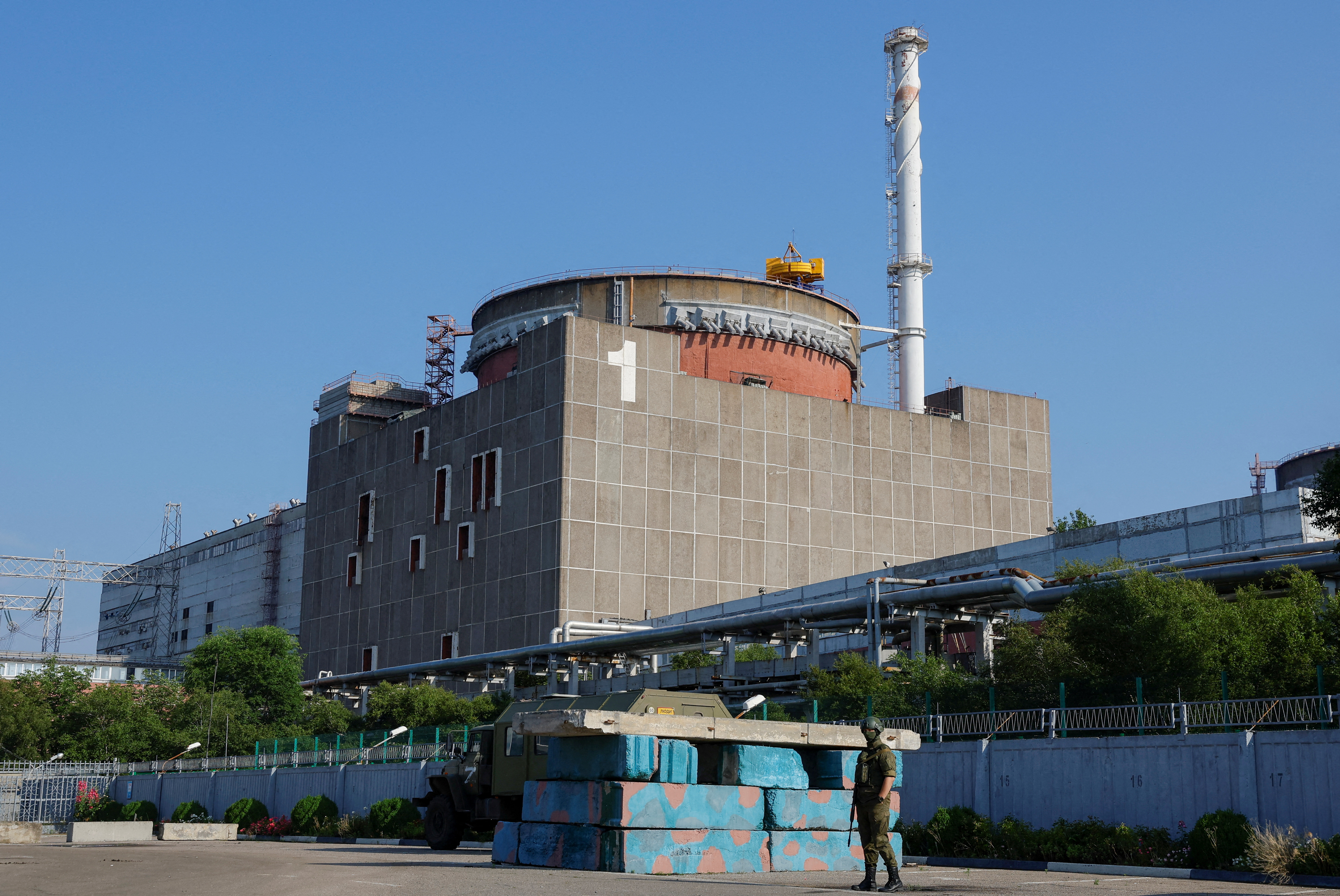 A Russian service member stands guard at a checkpoint near the Zaporizhzhia Nuclear Power Plant