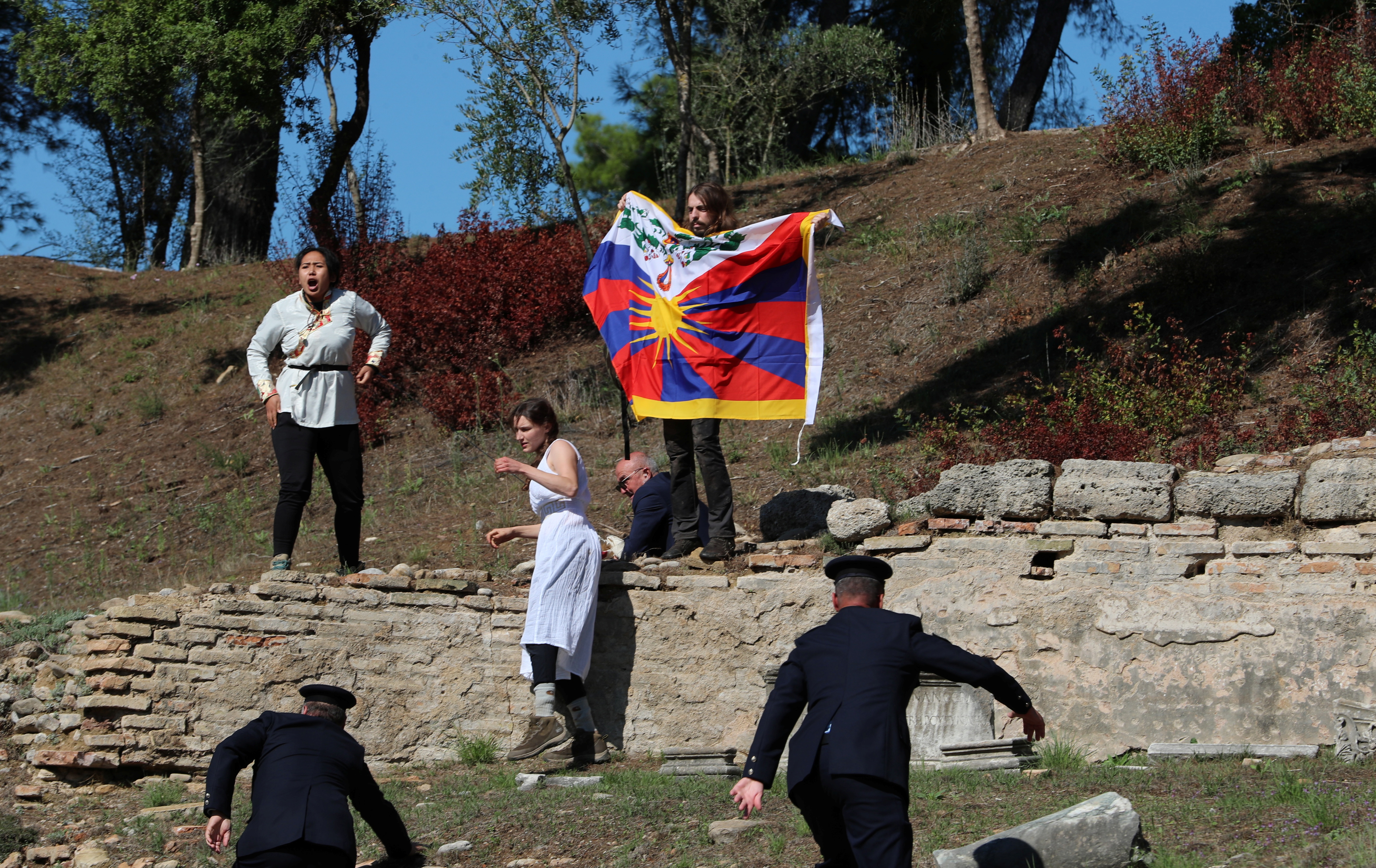 Winter Olympics - Lighting ceremony of the Olympic flame for the Beijing 2022 Winter Olympics - Ancient Olympia, Olympia, Greece - October 18, 2021 A protester holds a Tibetan flag during the Olympic flame lighting ceremony for the Beijing 2022 Winter Olympics REUTERS/Costas Baltas     
