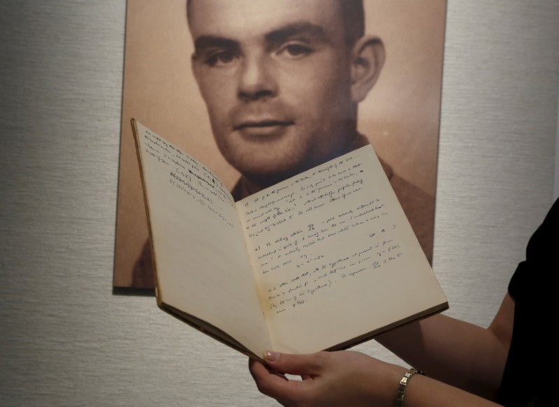 Notebook of British mathematician and pioneer in computer science Alan Turing is displayed in front of a photo of him during an auction preview in Hong Kong