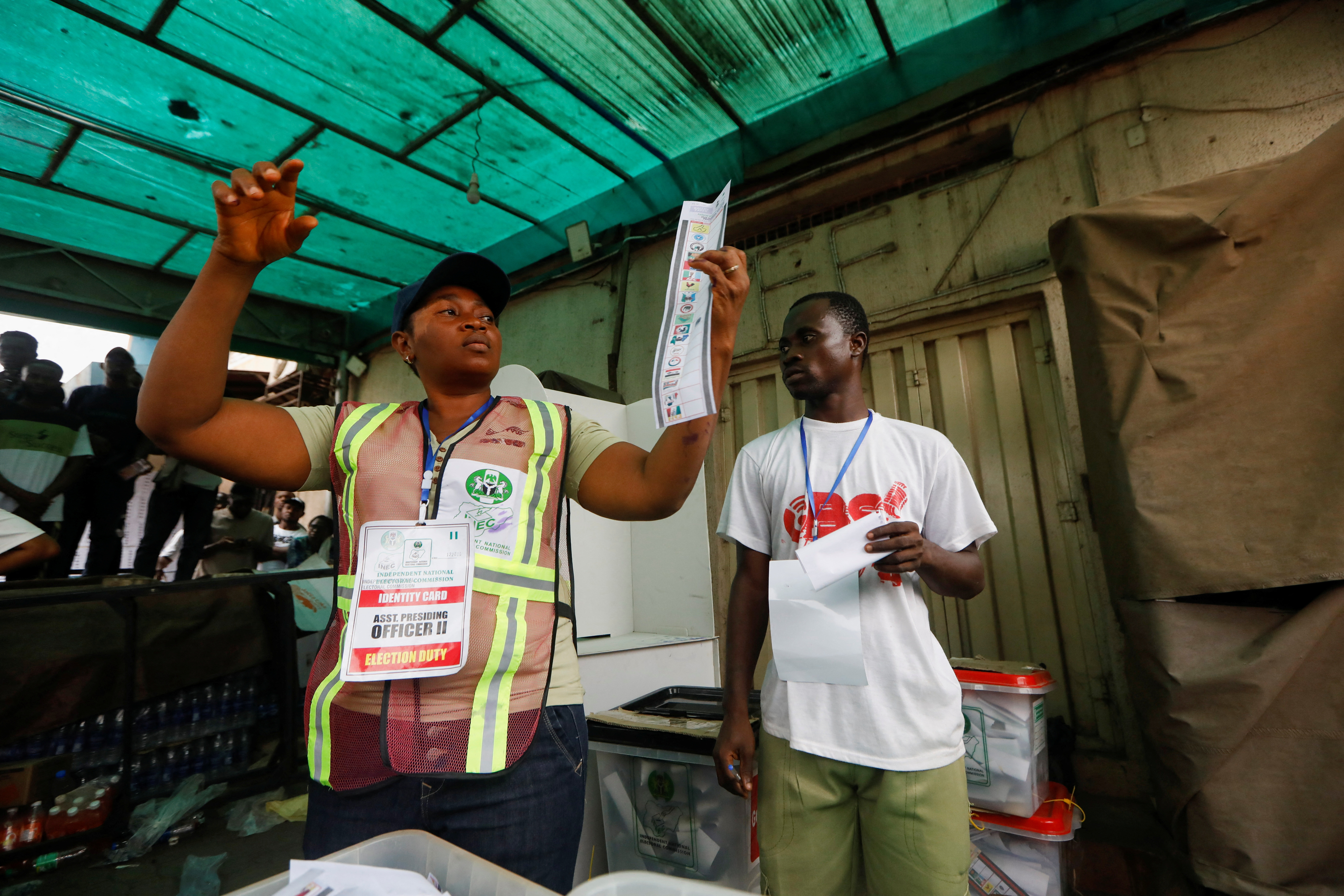 A poll worker holds up a ballot paper during the counting process of Nigeria's presidential election, at a polling unit in Awka